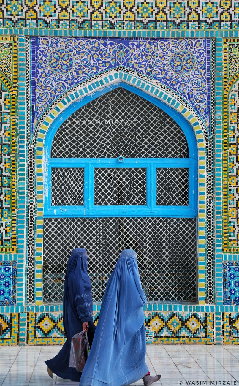 Traditional mosaic tile archways and pedestrian walkways outside the historic shrine complex in northern Afghanistan