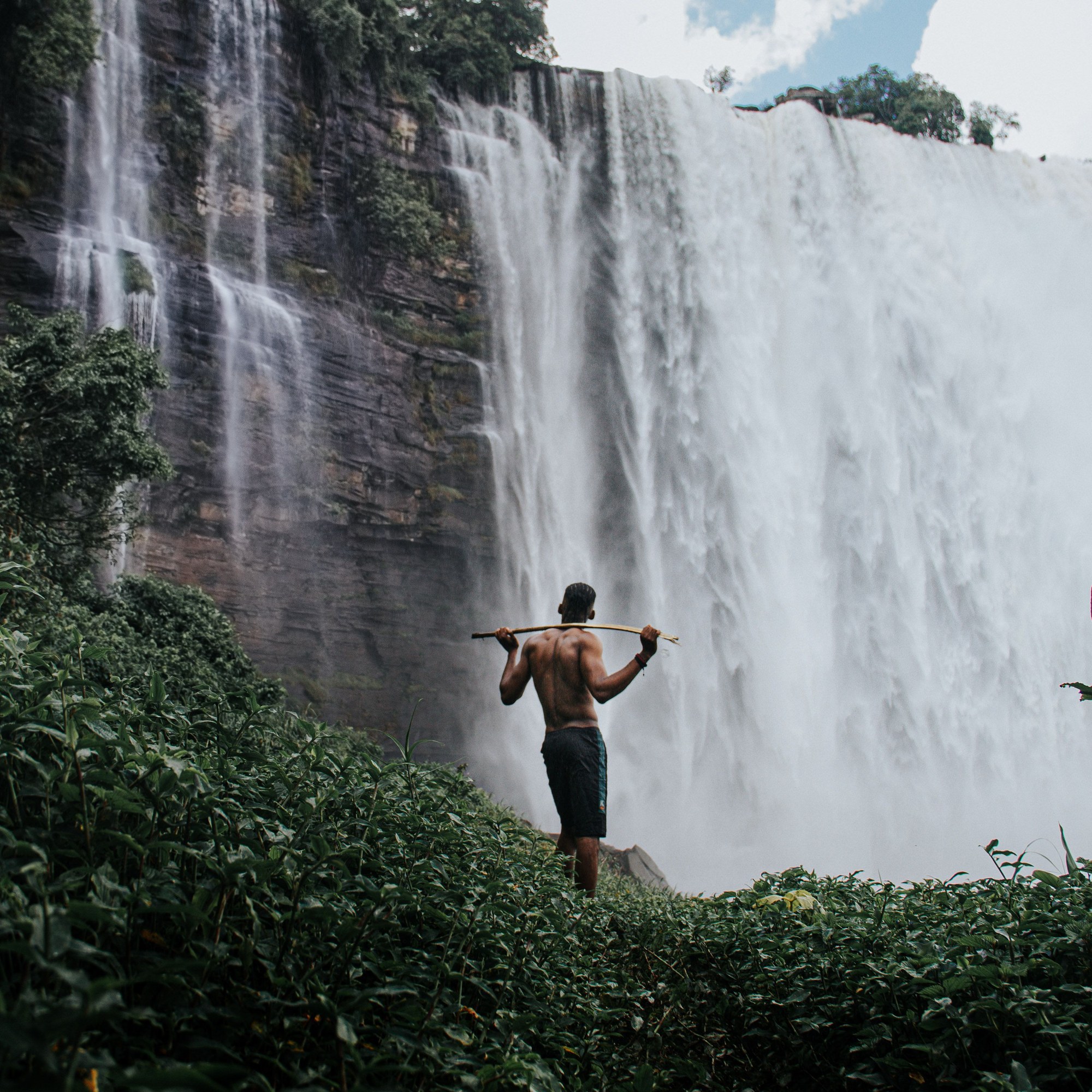 Spectator standing before the thundering cascades of Kalandula Falls in Malanje Angola