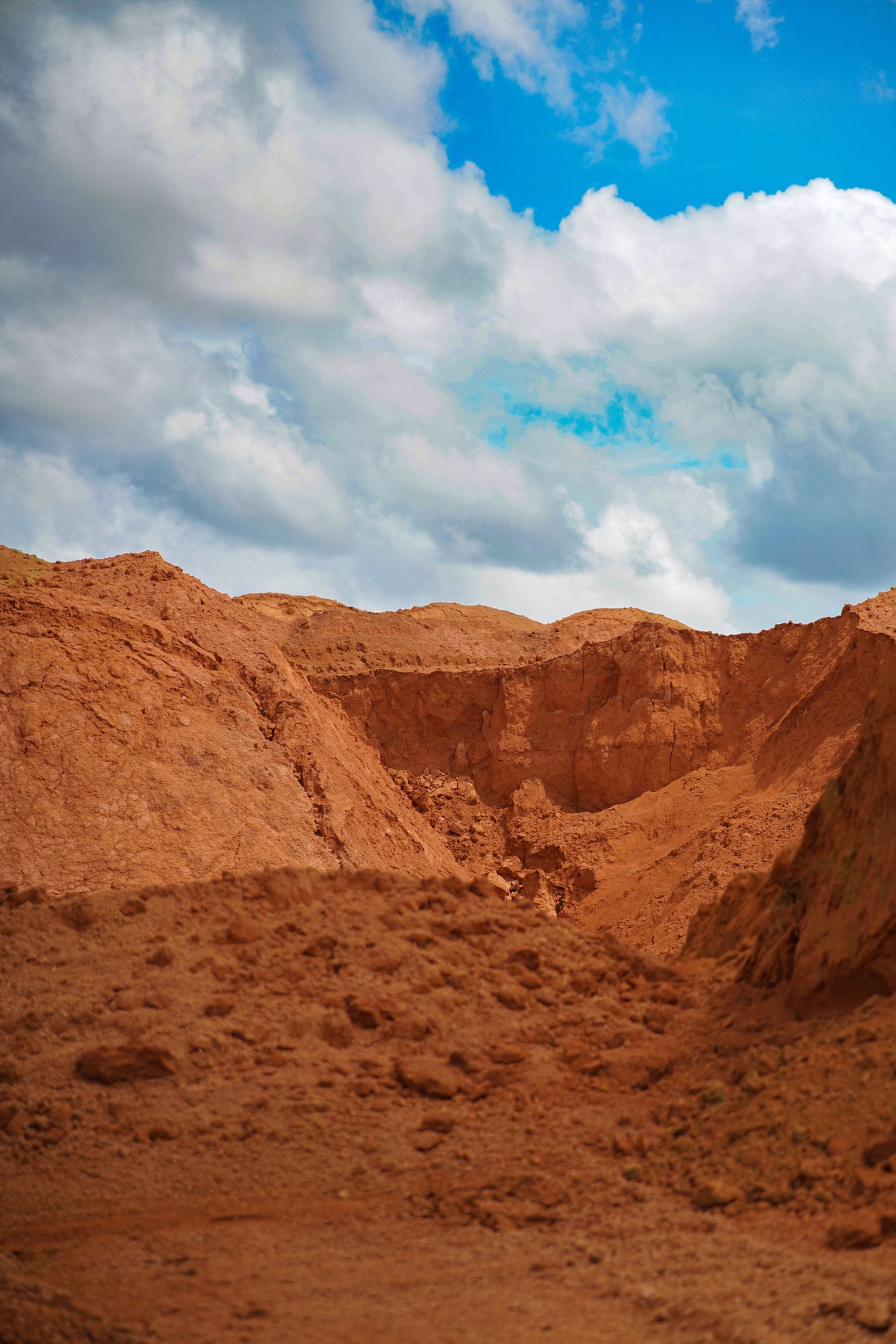 Dramatic eroded red clay canyon and jagged ridges under a blue sky