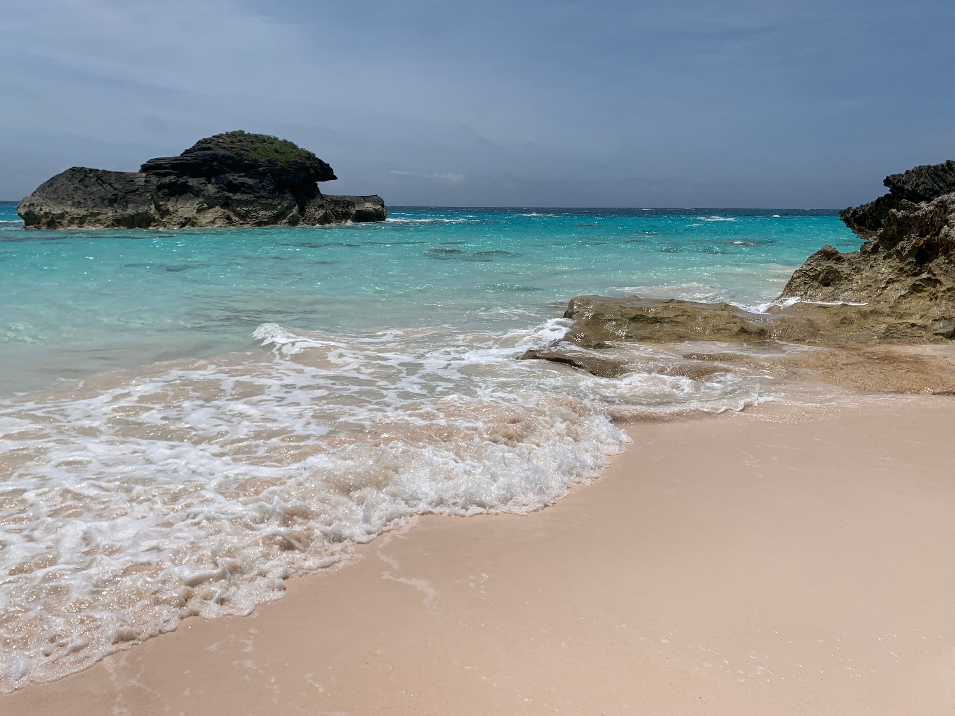 The iconic pink-tinted coral sands and turquoise waters of Horseshoe Bay