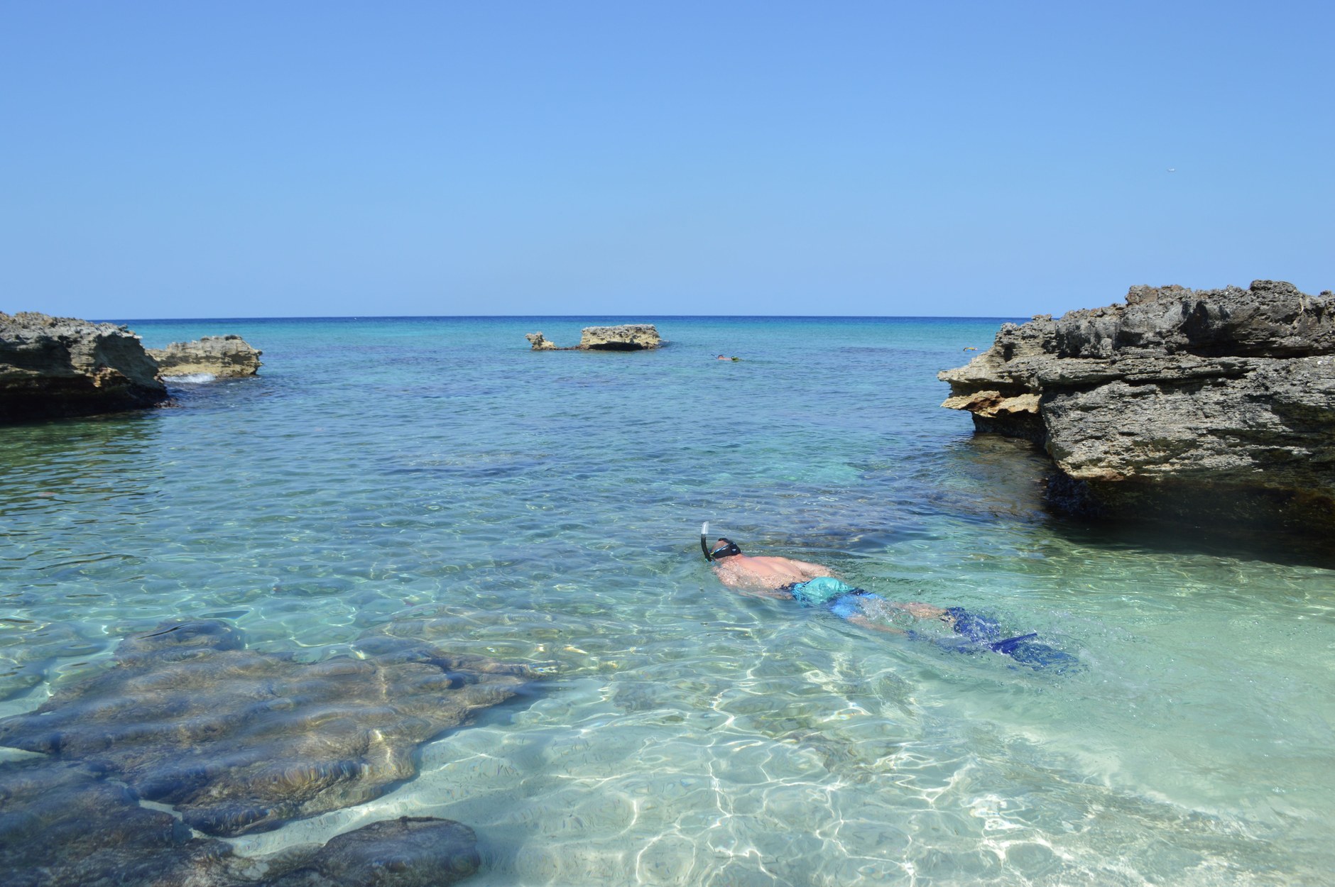 Calm limestone rock formations and clear snorkeling shallows at Tobacco Bay