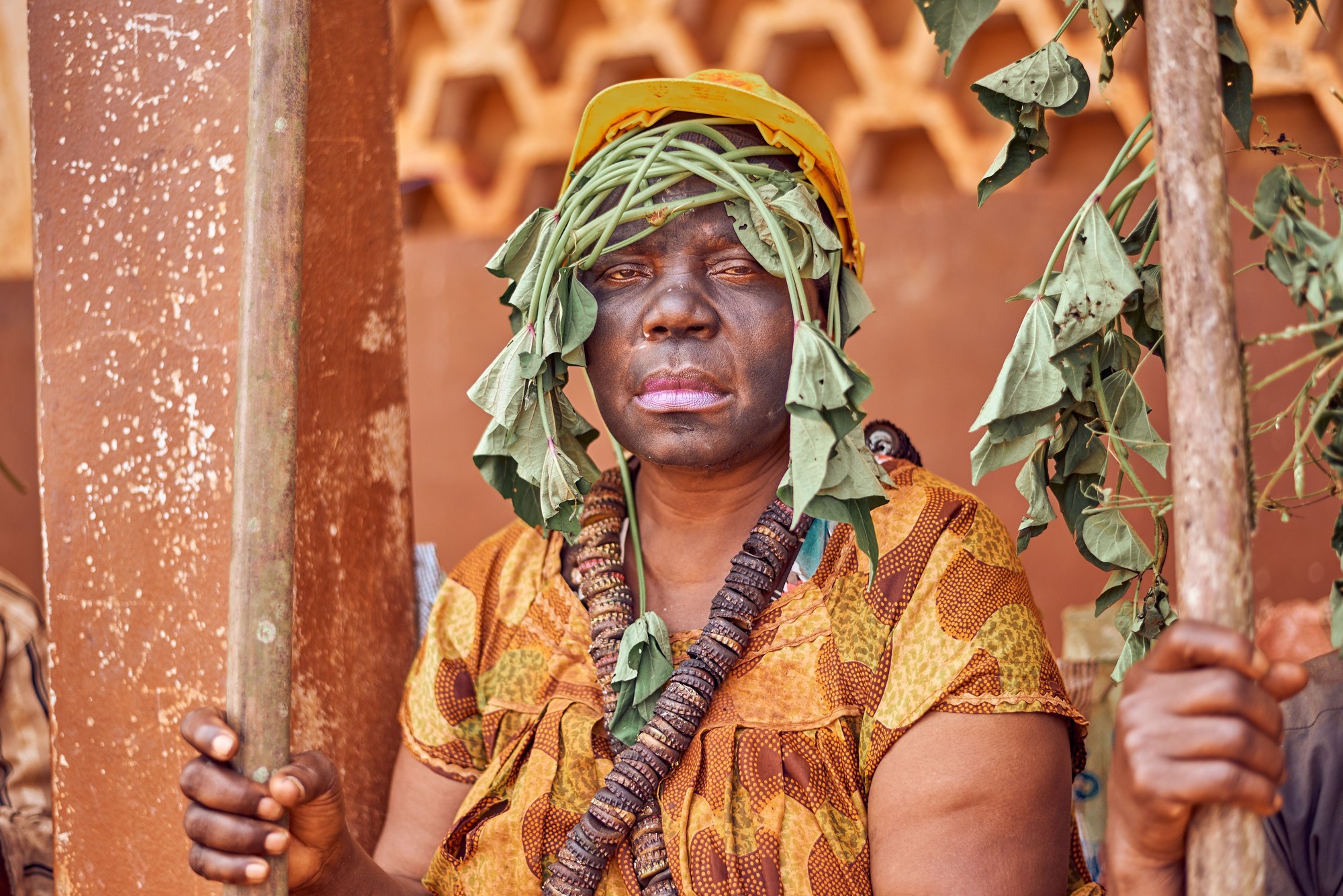 Participant in traditional ceremonial fabric and beaded attire during a cultural gathering in Batoufam