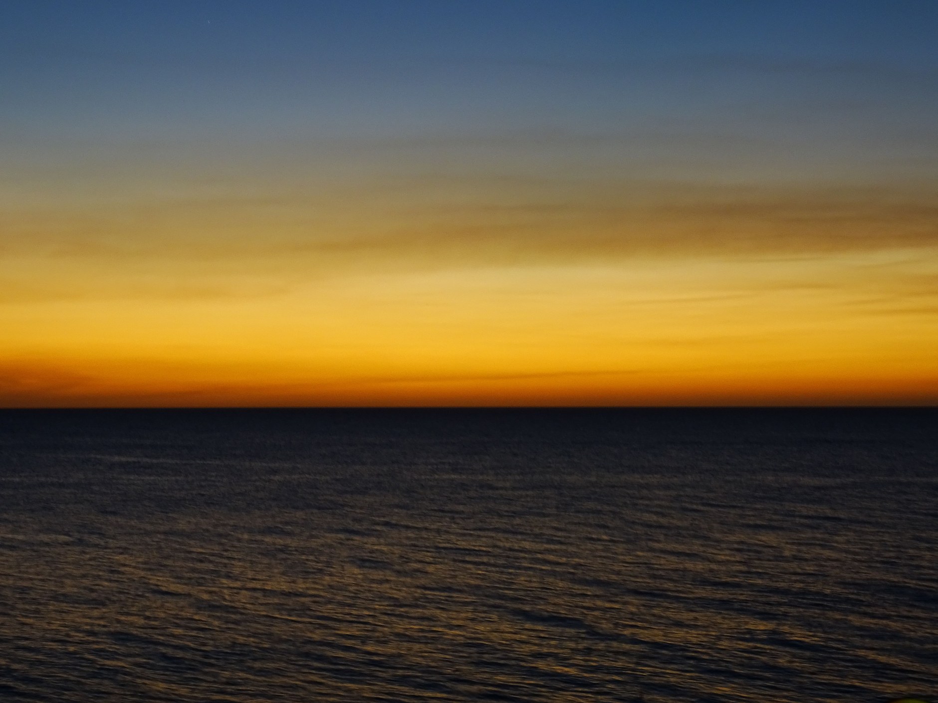 Golden evening light over the western coastal cliffs of Westpunt