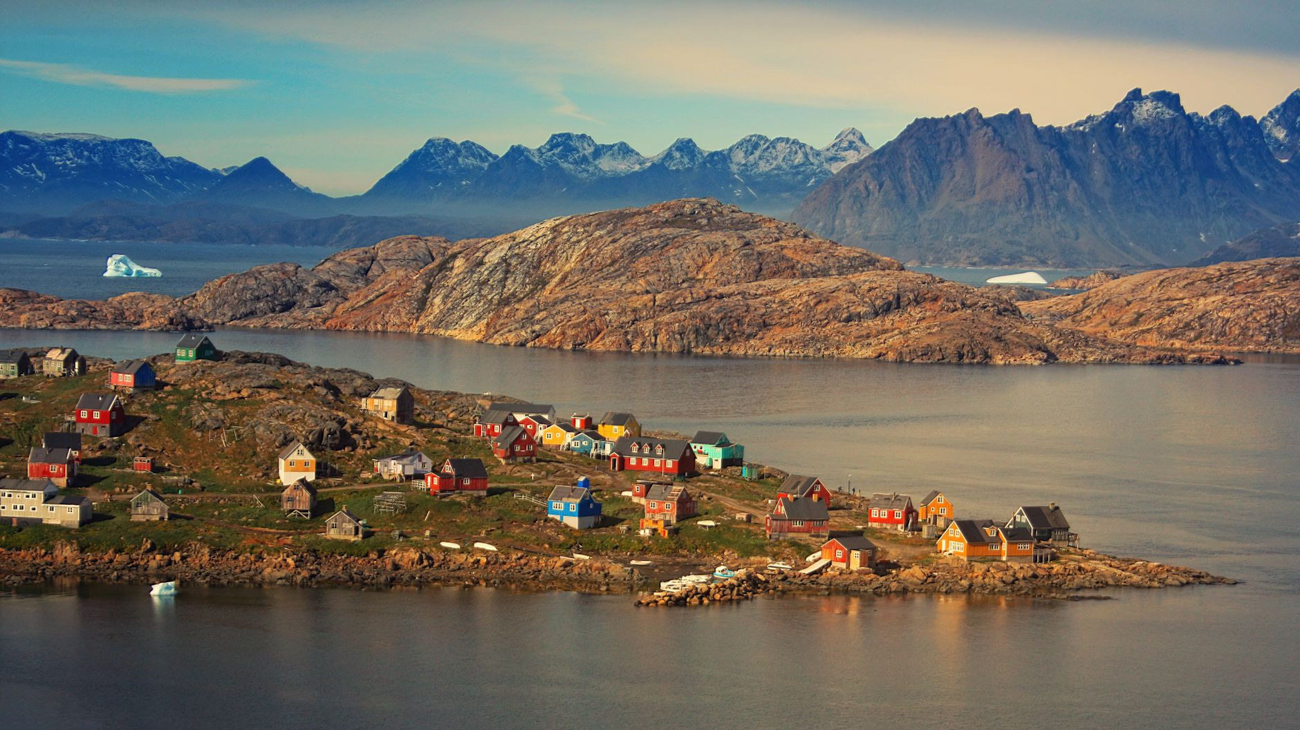 Traditional colorful wooden houses on rocky coastal bluffs in Greenland