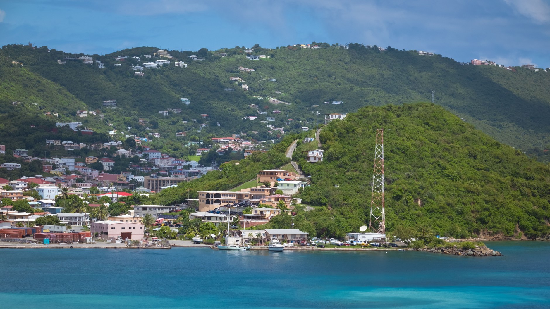 Traditional colorful boats anchored along a Grenadines coastal harbor waterfront