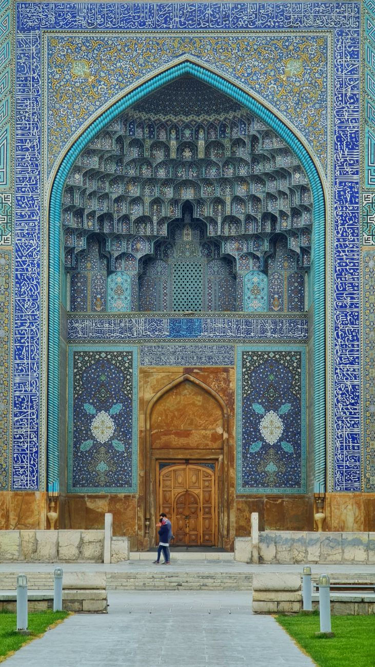Massive portal archway of the Shah Mosque in Isfahan covered in intricate cobalt-blue tile muqarnas vaulting