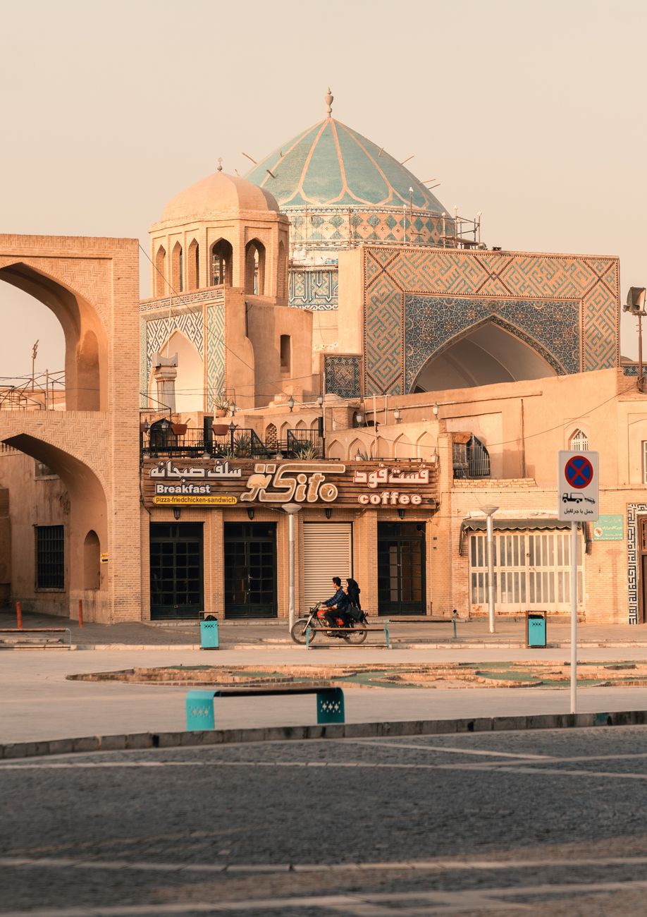 Iconic three-story arched facade of the Amir Chakhmaq Complex in the desert city of Yazd under clear blue skies