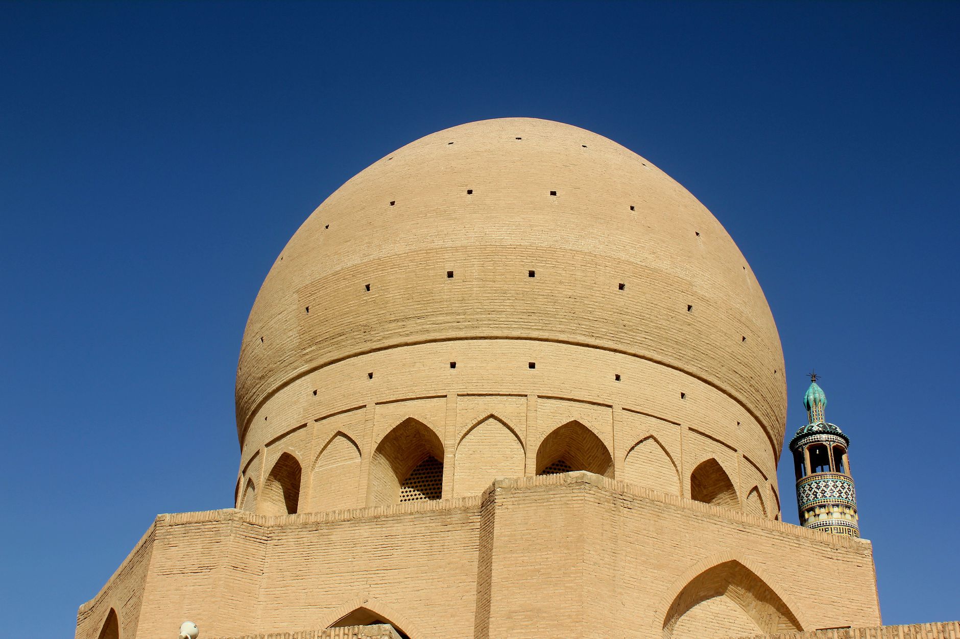 Soaring fourteenth-century minarets and tiled dome of the Jameh Mosque in the desert city of Yazd