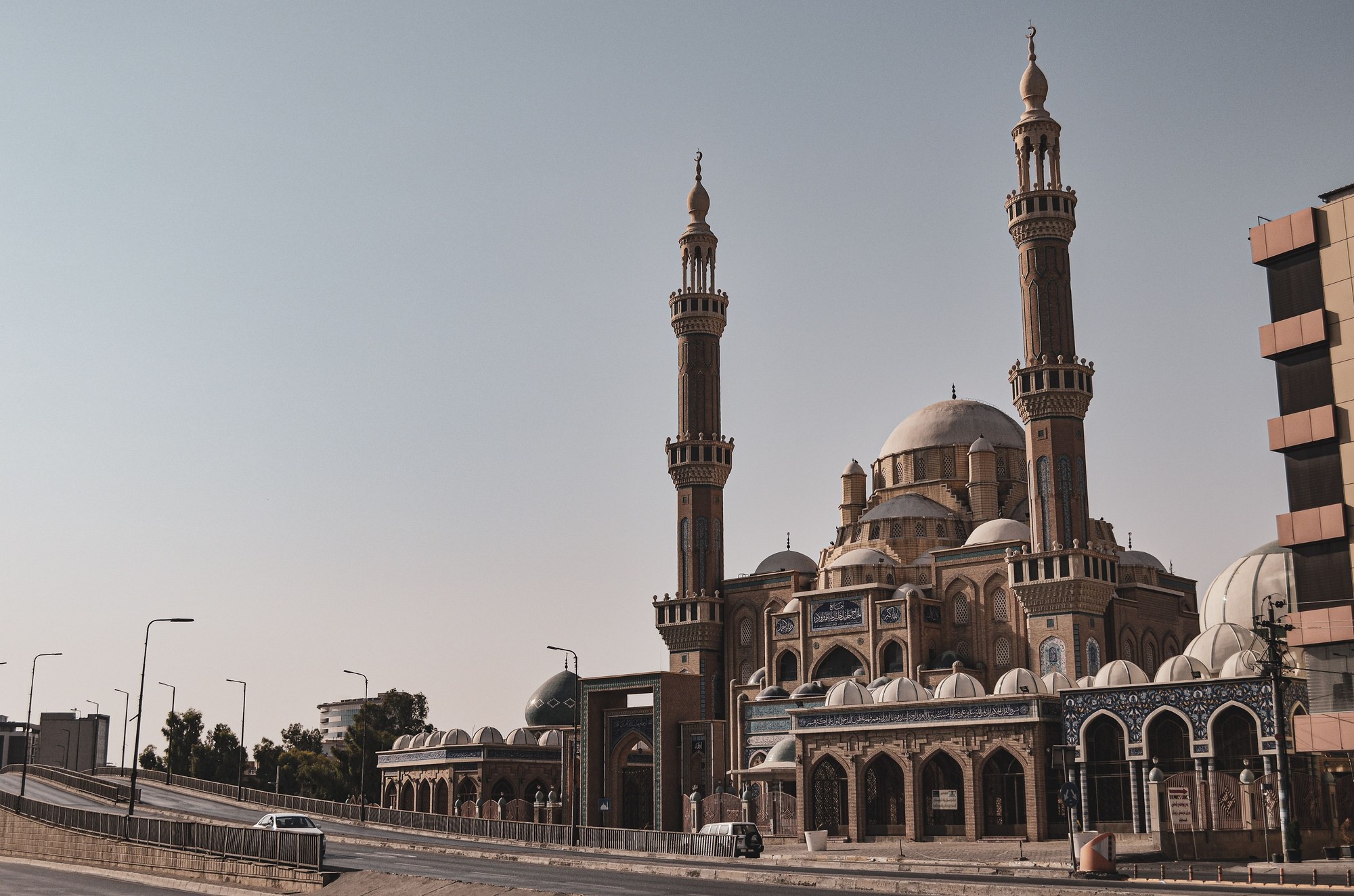 Magnificent exterior of Jalil Khayat Mosque in Erbil featuring intricate Ottoman-style blue domes and minarets