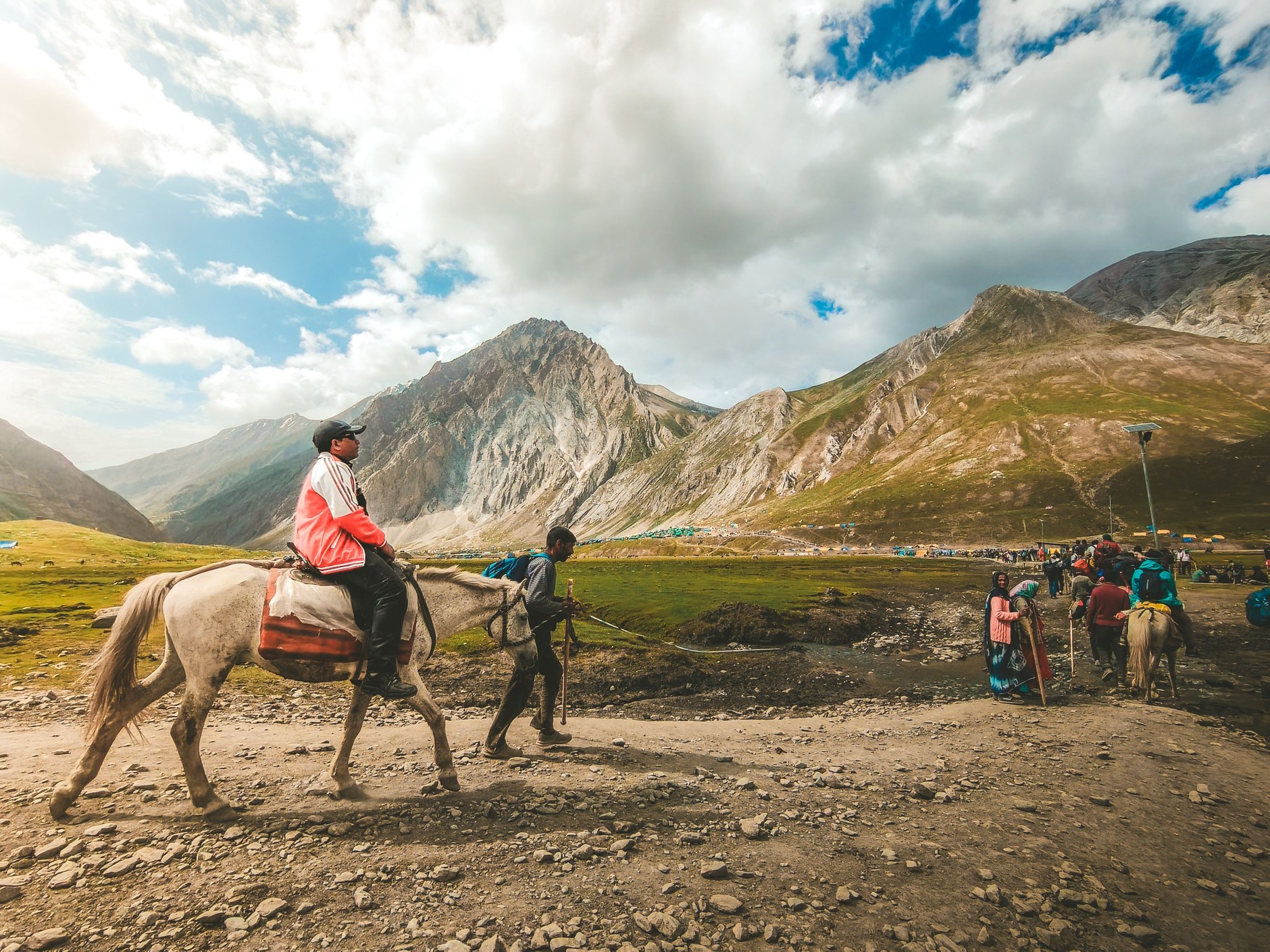 Horse riders trekking across sweeping treeless alpine grasslands in the Lesotho highlands
