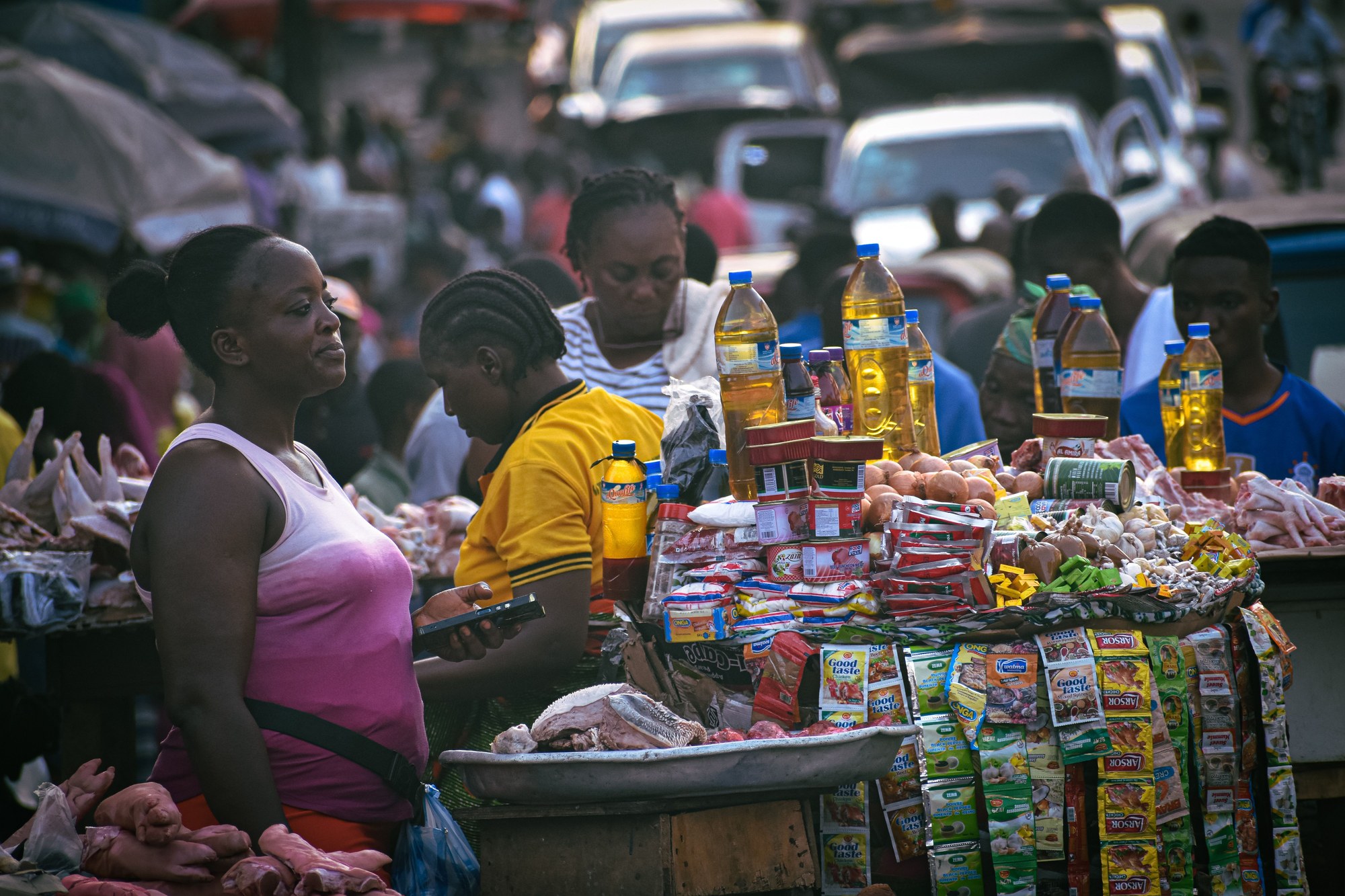 Busy open-air street market in Monrovia with vendors displaying fresh fruits and household goods