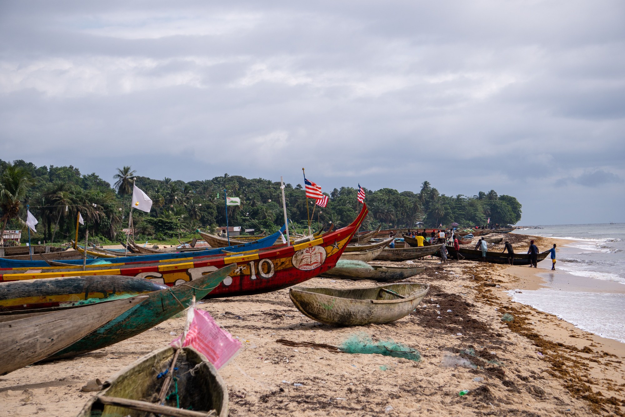 Colorful wooden fishing canoes lined up along the golden sandy beaches of Robertsport in Grand Cape Mount County