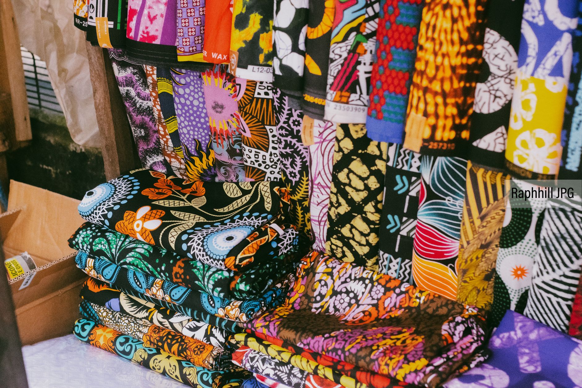 Patterned West African woven textiles and mud cloth fabrics displayed in market stalls
