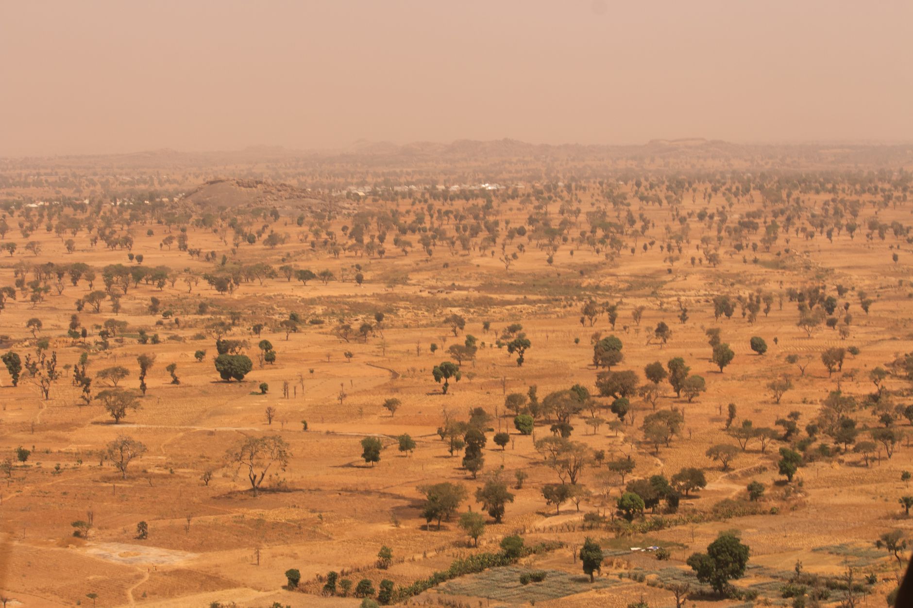 Expansive arid landscape and red-earth plains across the Sahel region of West Africa