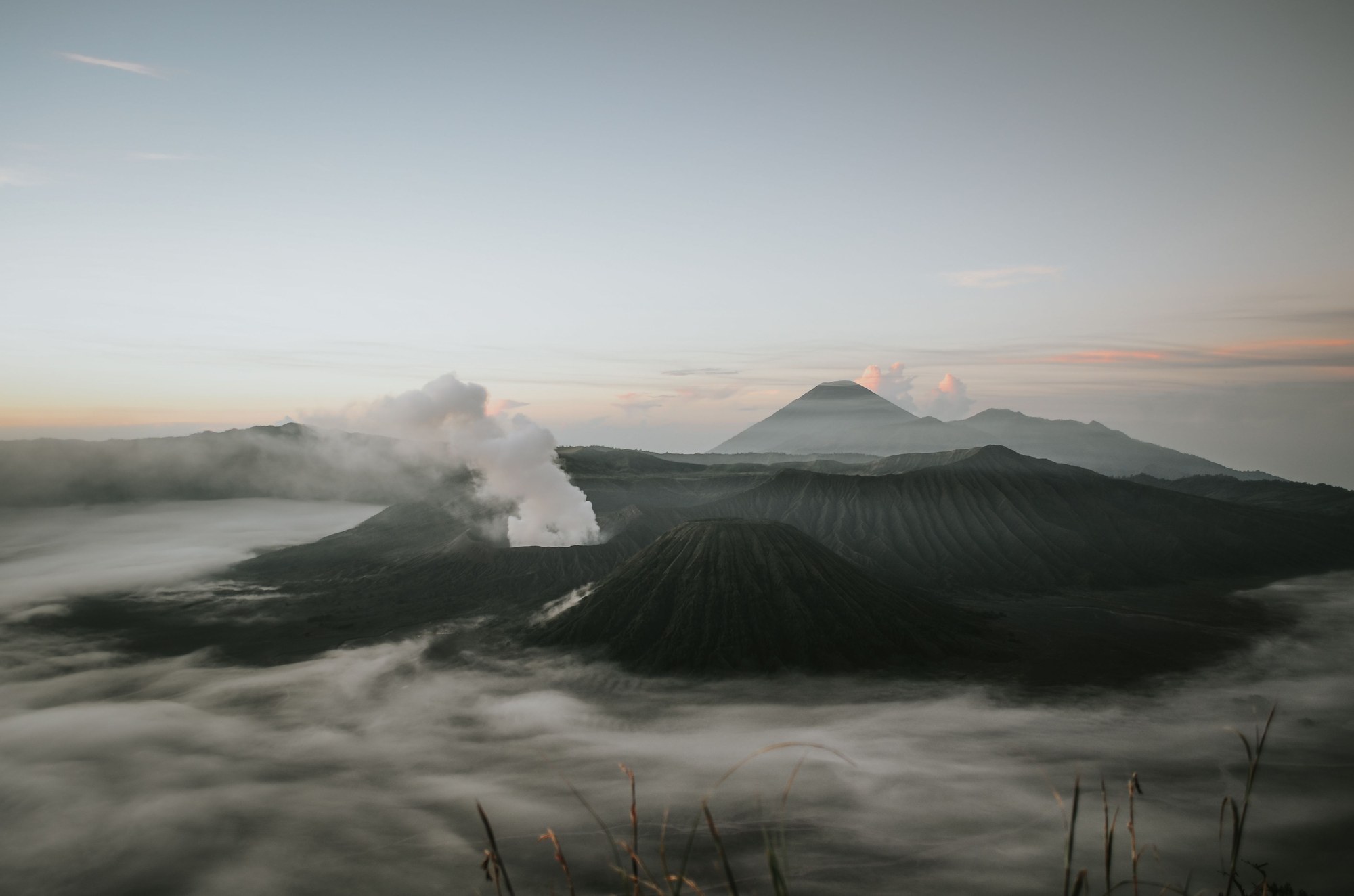 Expansive view of volcanic caldera slopes and rising steam