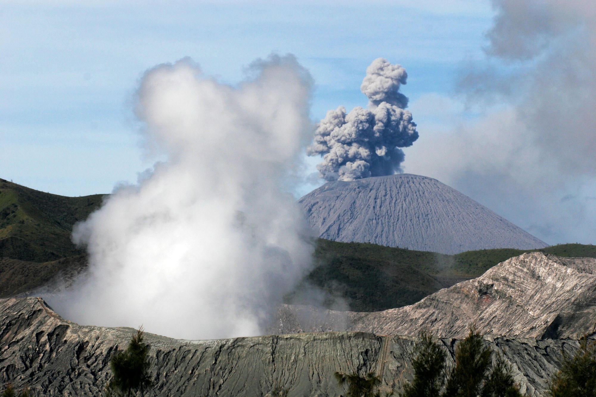 Dramatic volcanic peak with rising ash plume and rugged slopes