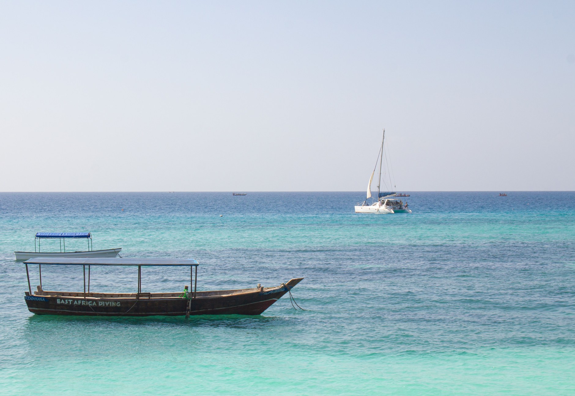 Traditional wooden dhow sailboat cruising across the calm waters of Vilankulos bay
