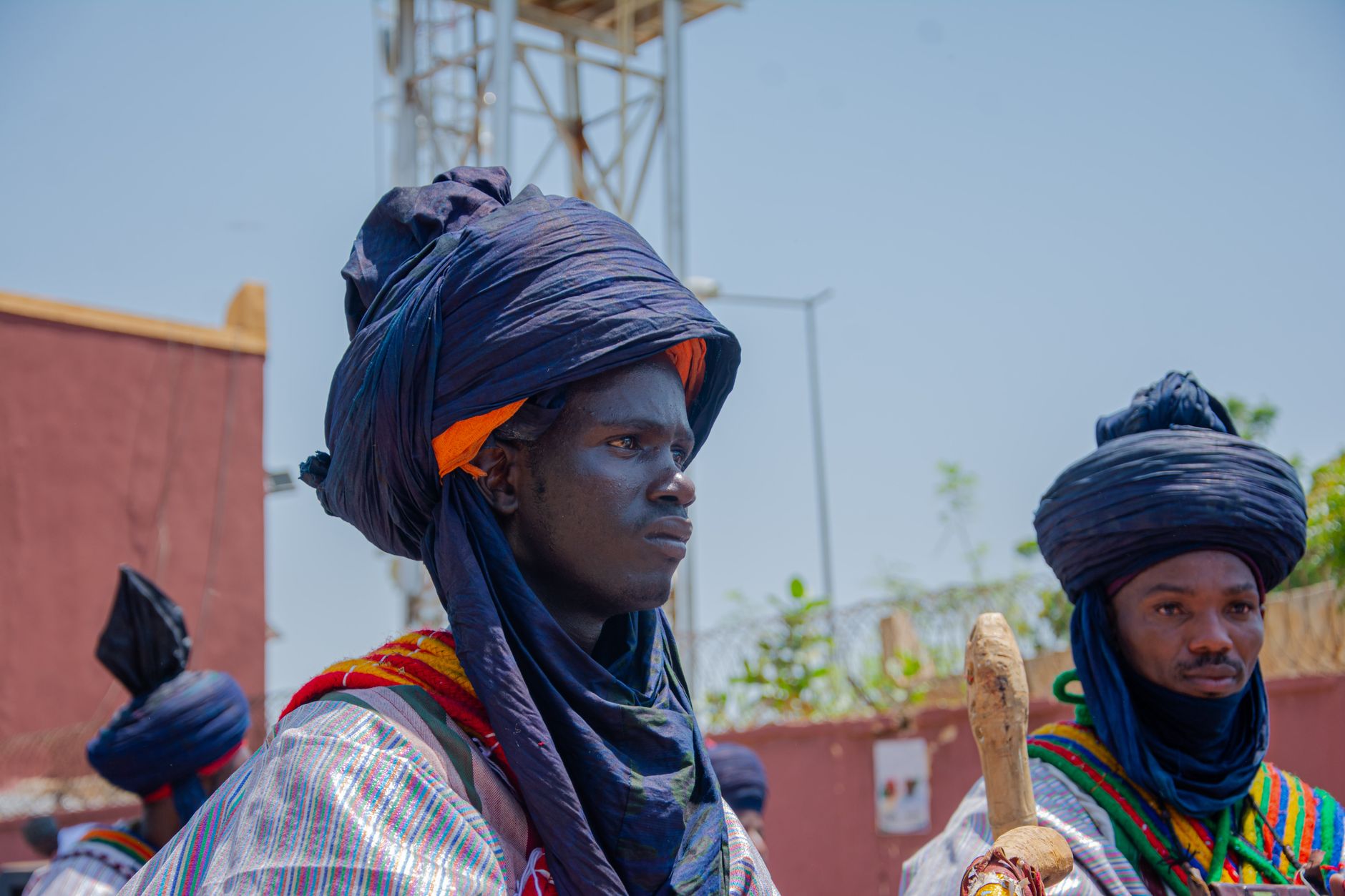 Tuareg men in traditional indigo robes and tagelmust turbans marching during a cultural event in Niamey