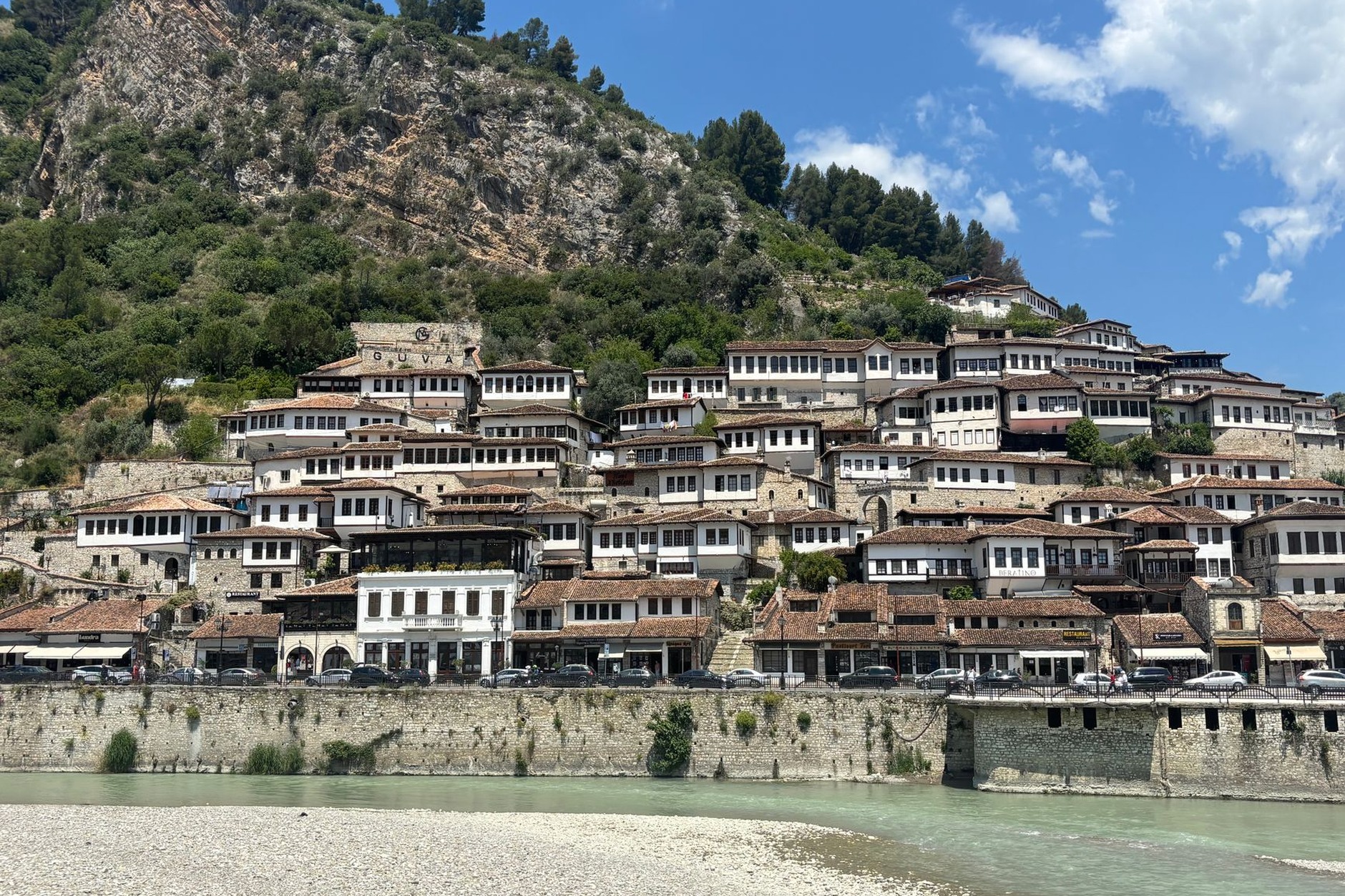 Tiered white Ottoman houses with hundreds of symmetrical wooden windows rising along the hillside of Berat Albania