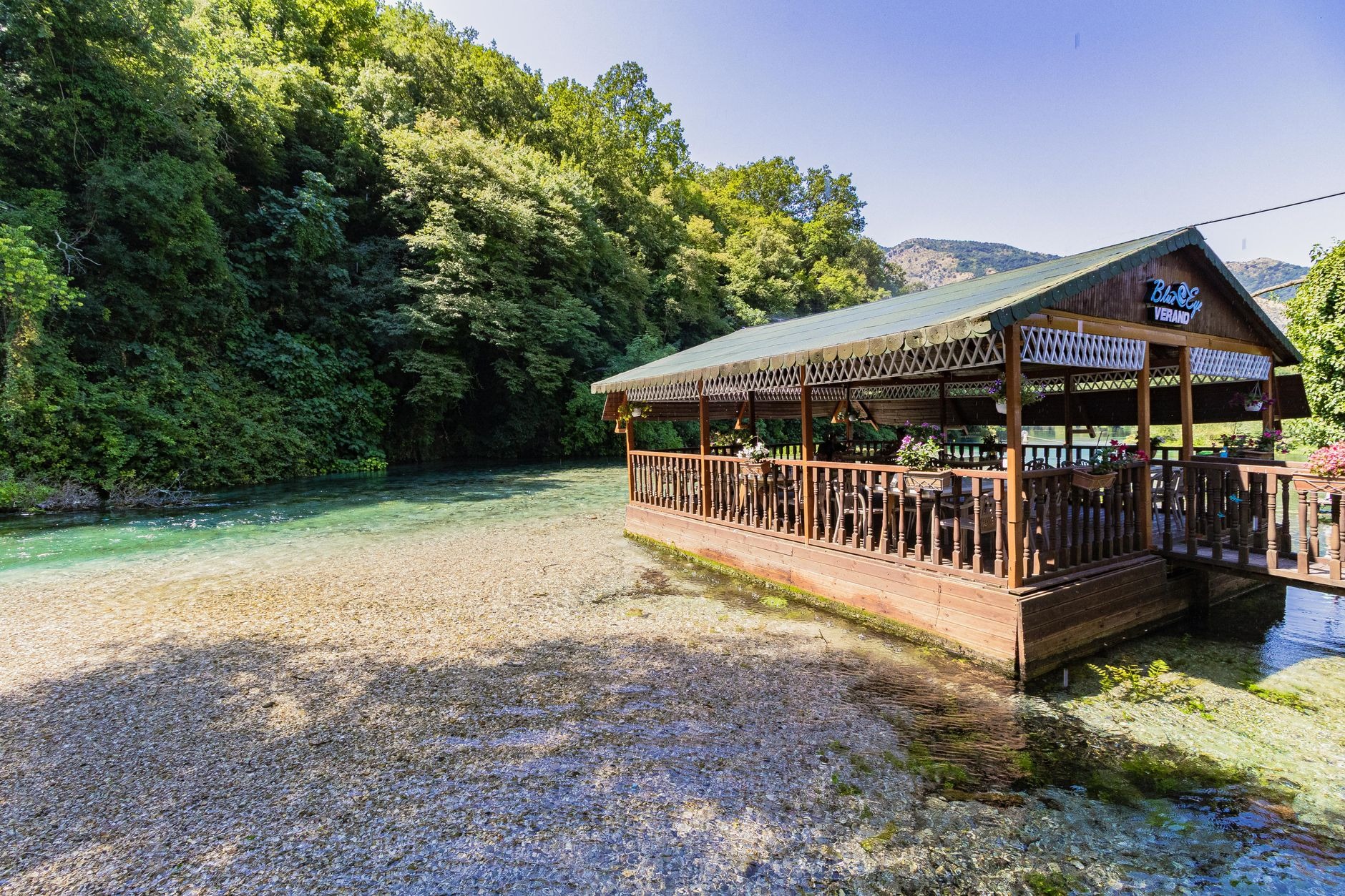 Vibrant deep turquoise and emerald crystal clear karst natural spring water pool of Syri i Kalter the Blue Eye in Albania