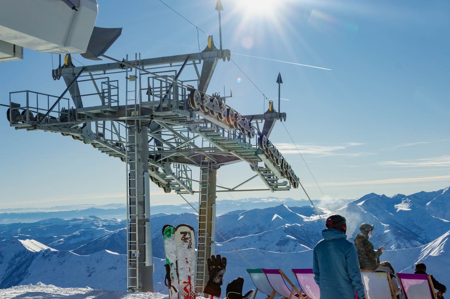 Wide groomed ski pistes and modern chairlifts cutting across deep snowfields in sunny winter conditions