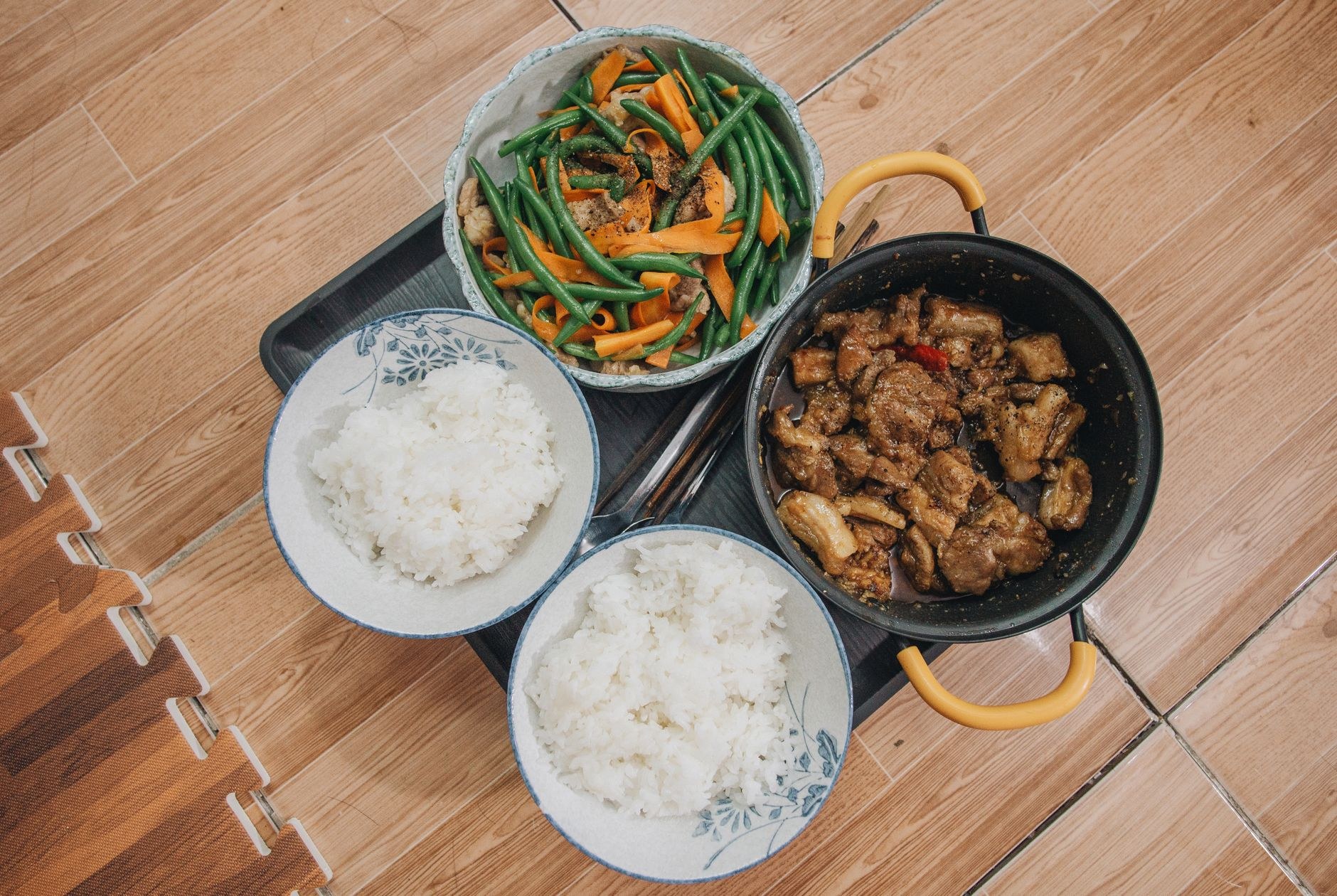 A steaming earthenware bowl of rich meat and vegetable escudella stew with pasta shells and white beans