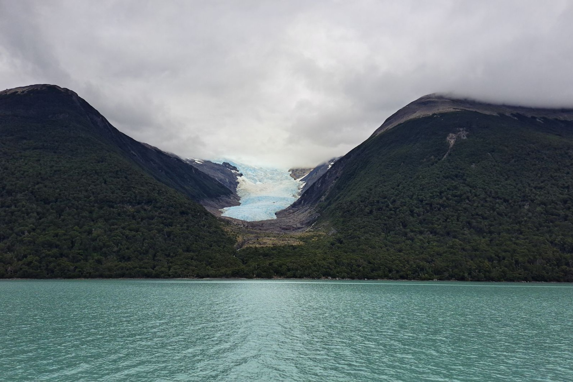 Glacial turquoise waters of Lake Argentino framed by rugged snow-dusted Andean mountain peaks in Patagonia
