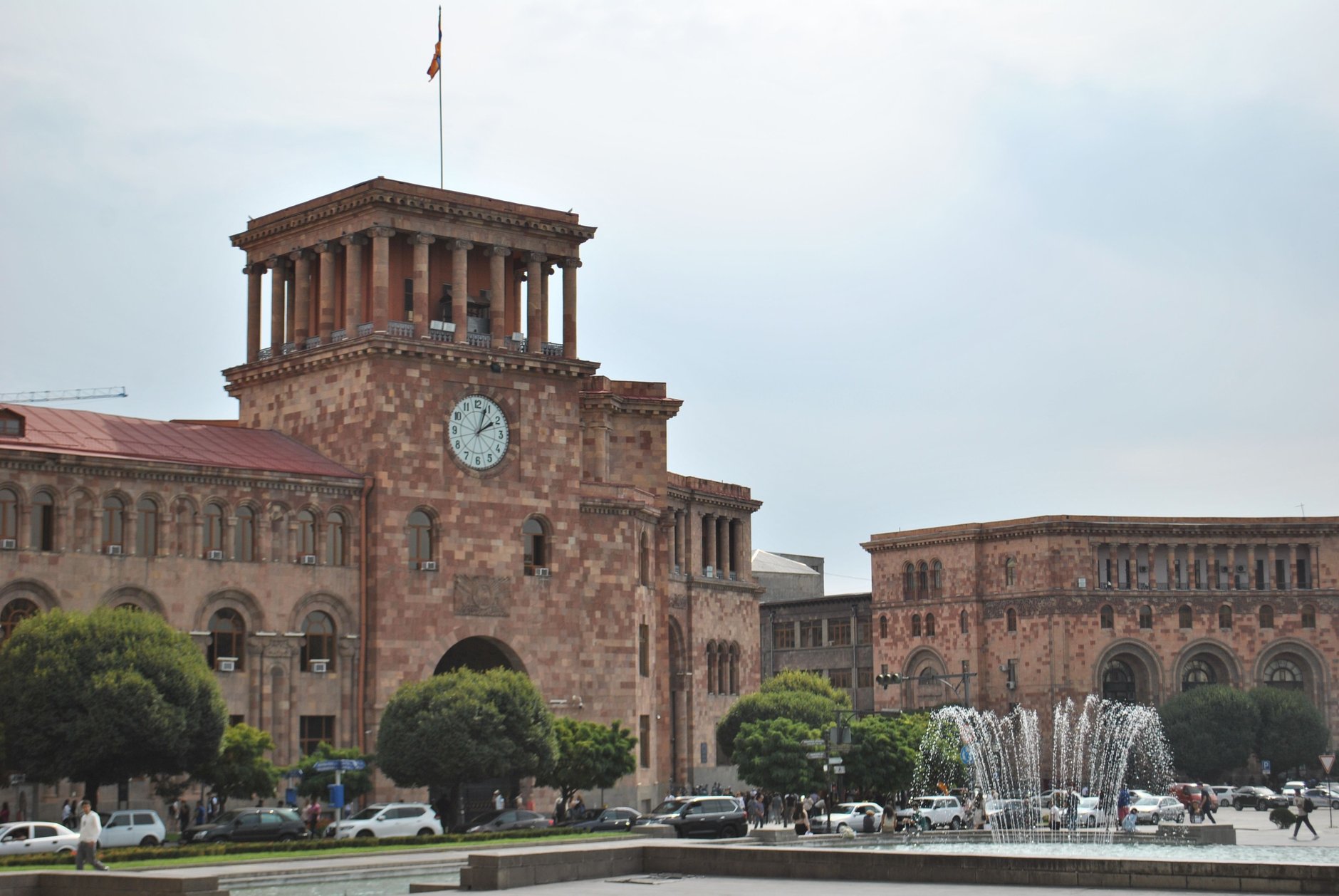 Neoclassical government buildings constructed from pink volcanic tuff stone enclosing Republic Square in central Yerevan