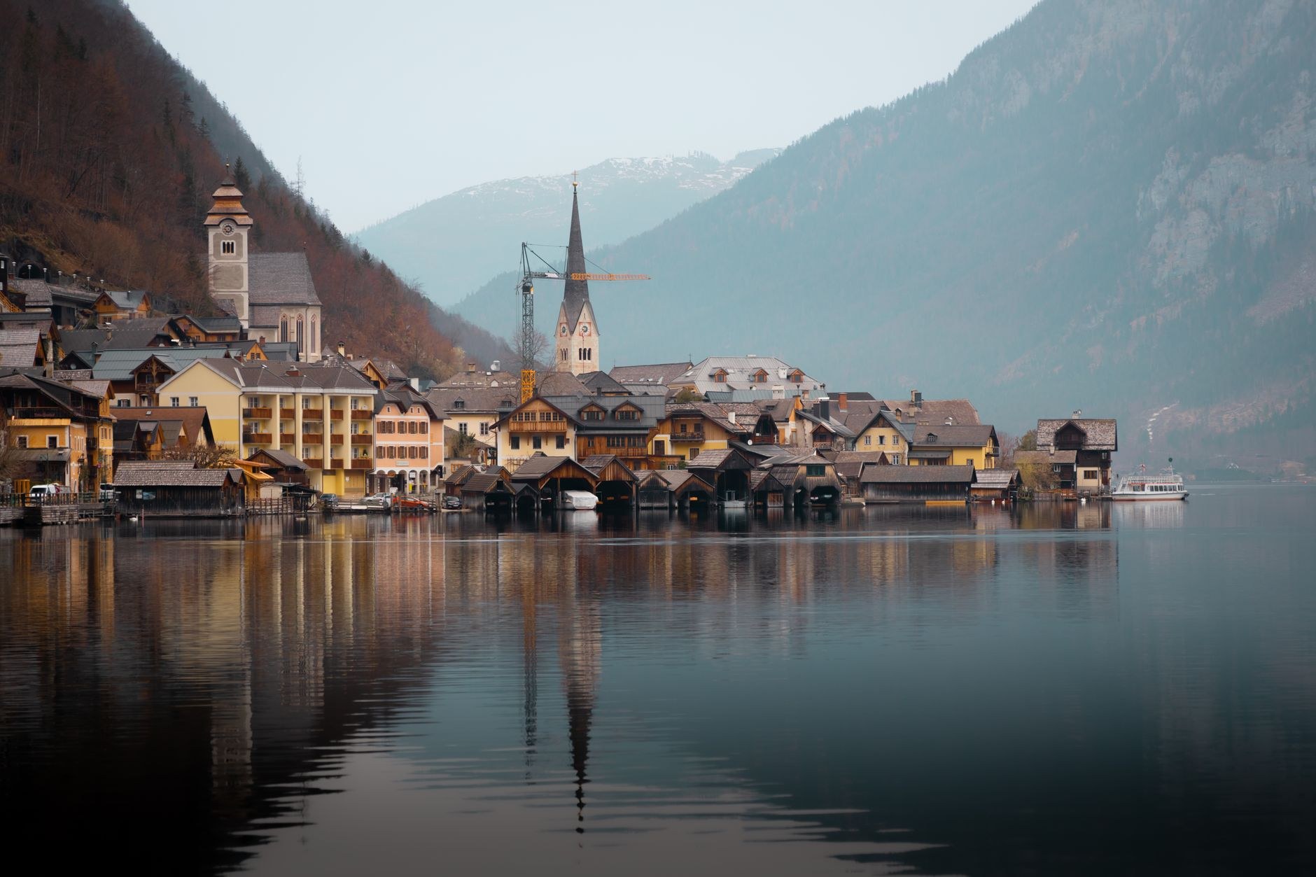 Hallstatt village and church steeple on the edge of the Hallstätter See framed by alpine peaks