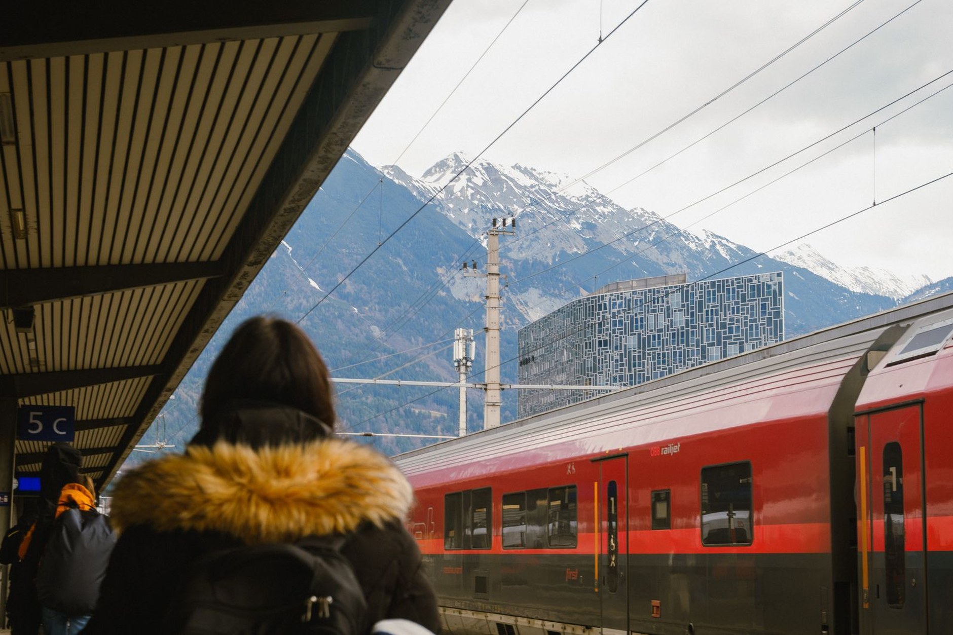 An ÖBB Railjet high-speed train winding through an Austrian alpine valley