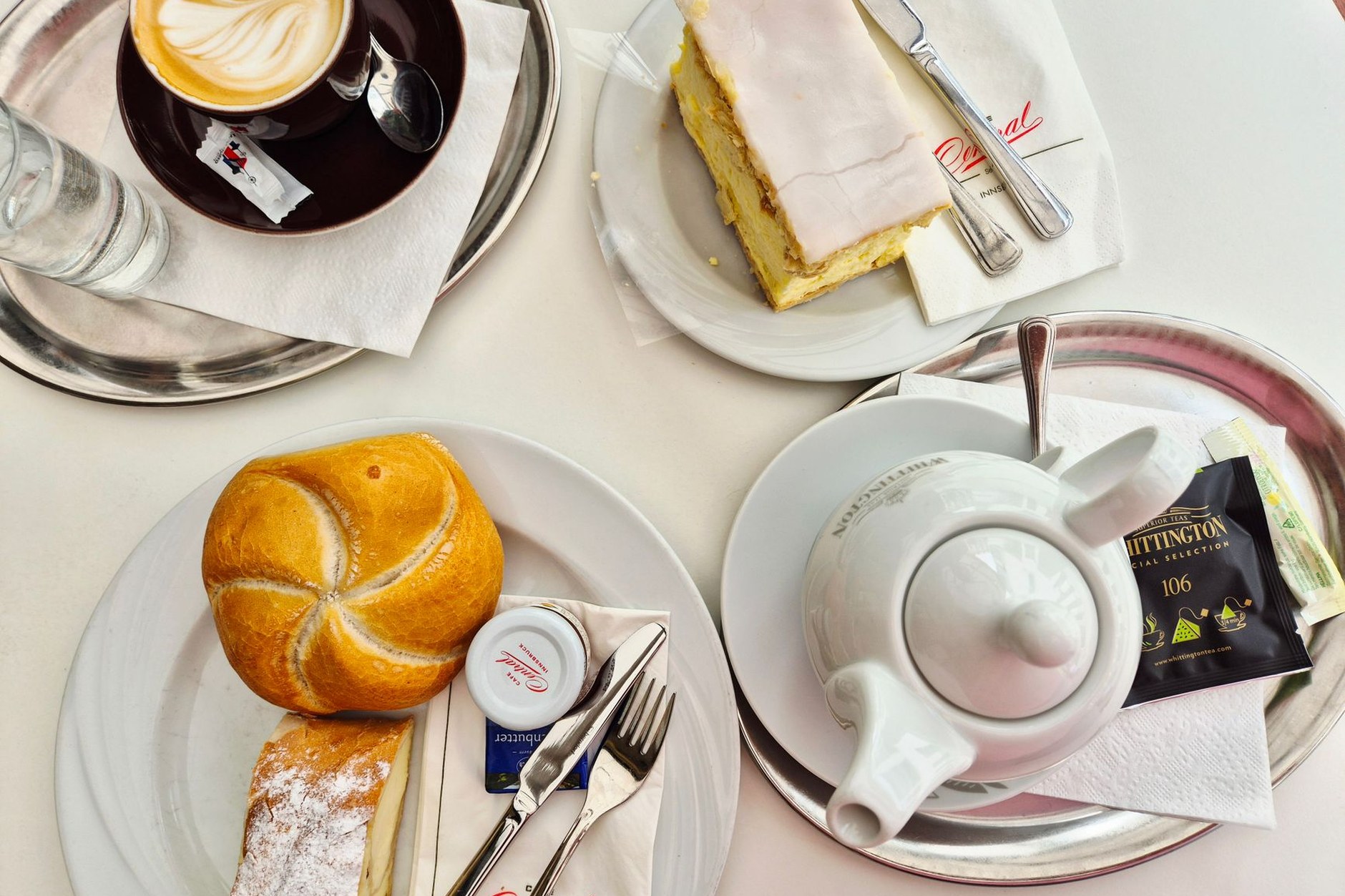 A classic Viennese coffeehouse presentation with Melange coffee, chocolate Sachertorte, and glass of water