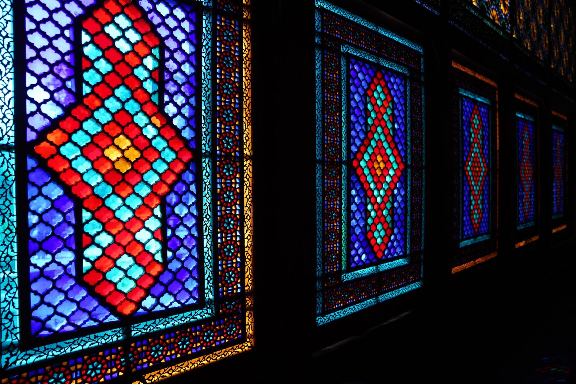 Ornate two-story summer palace facade decorated with floral frescoes and intricate shebeke stained-glass lattice windows