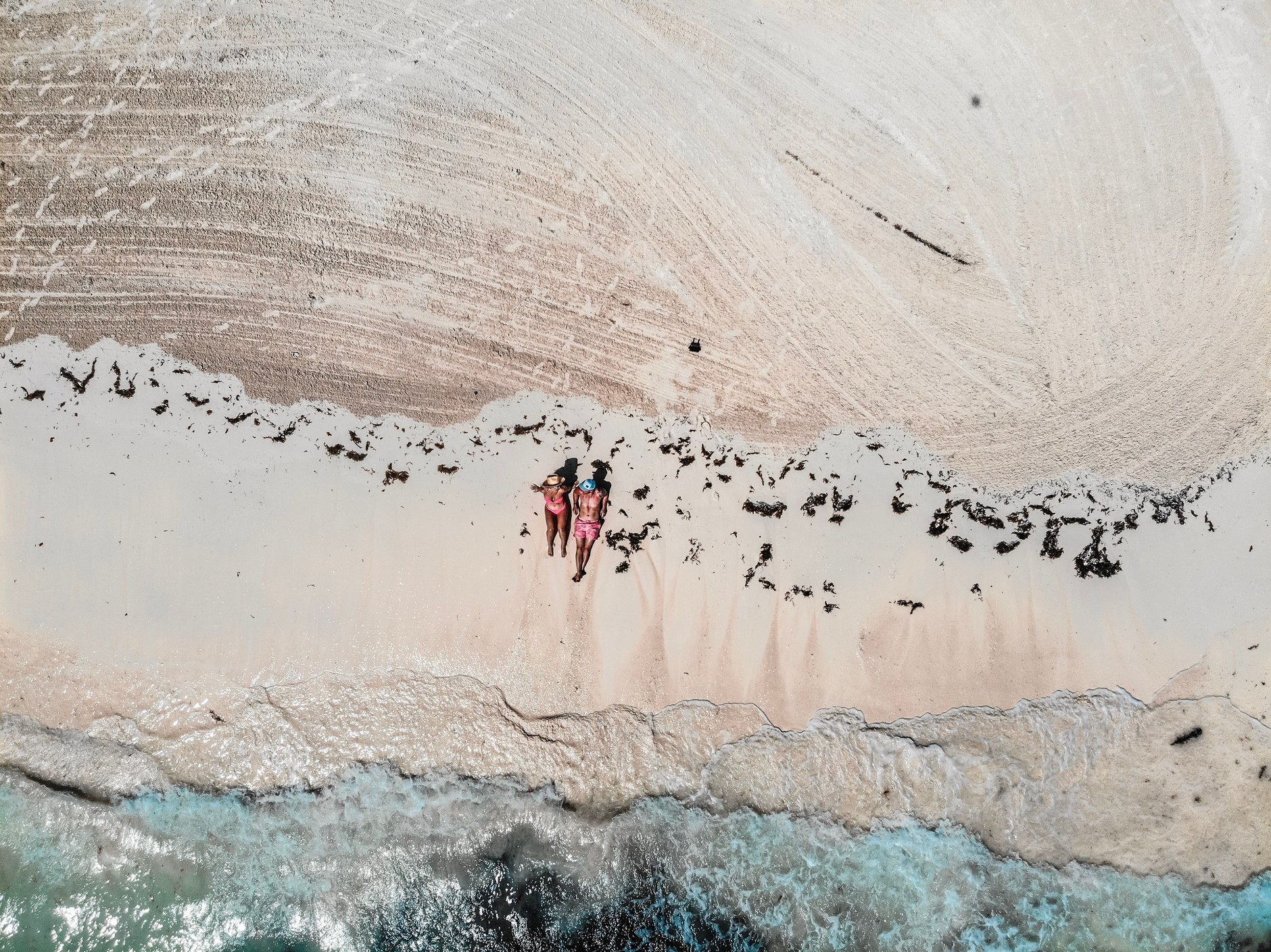 Powder-soft white sand crescent meeting clear azure ocean waters along the coast of Exuma