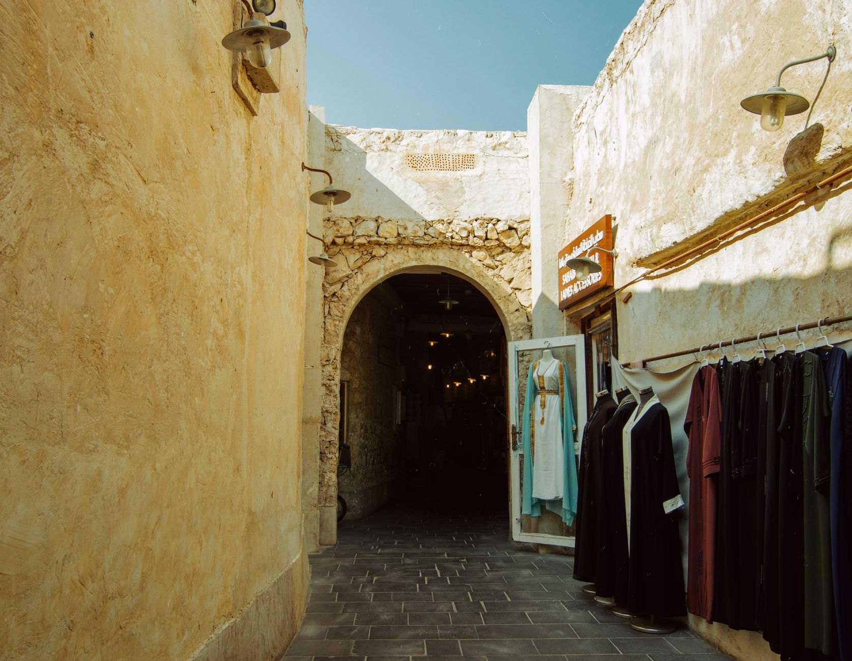 Historic Bab Al Bahrain arched stone gateway opening into the bustling pedestrian alleys of Manama Souq