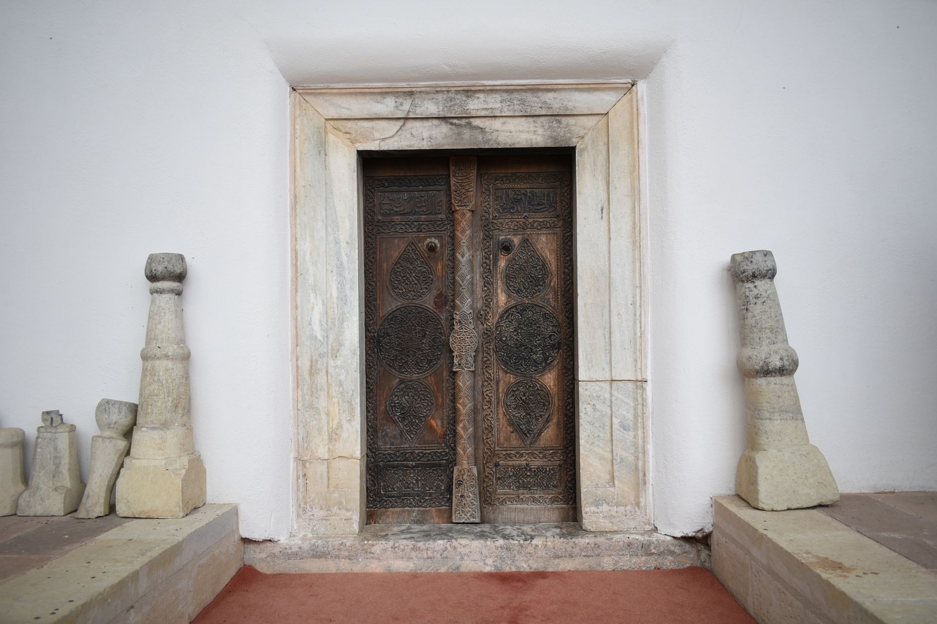 Traditional coral stone courtyard house featuring intricate carved wooden doorways and decorative plasterwork