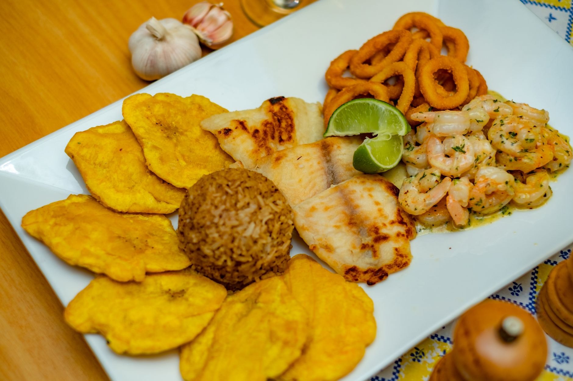 Sizzling platter of seasoned grilled flying fish, sweet fried plantains, and Bajan macaroni pie served at an outdoor stall