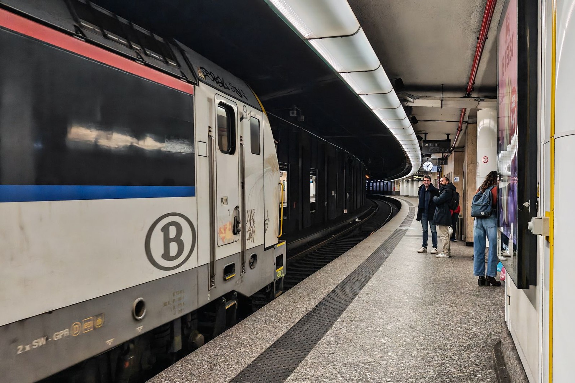 Modern Belgian passenger train at a spotless railway station platform connecting Flemish art cities