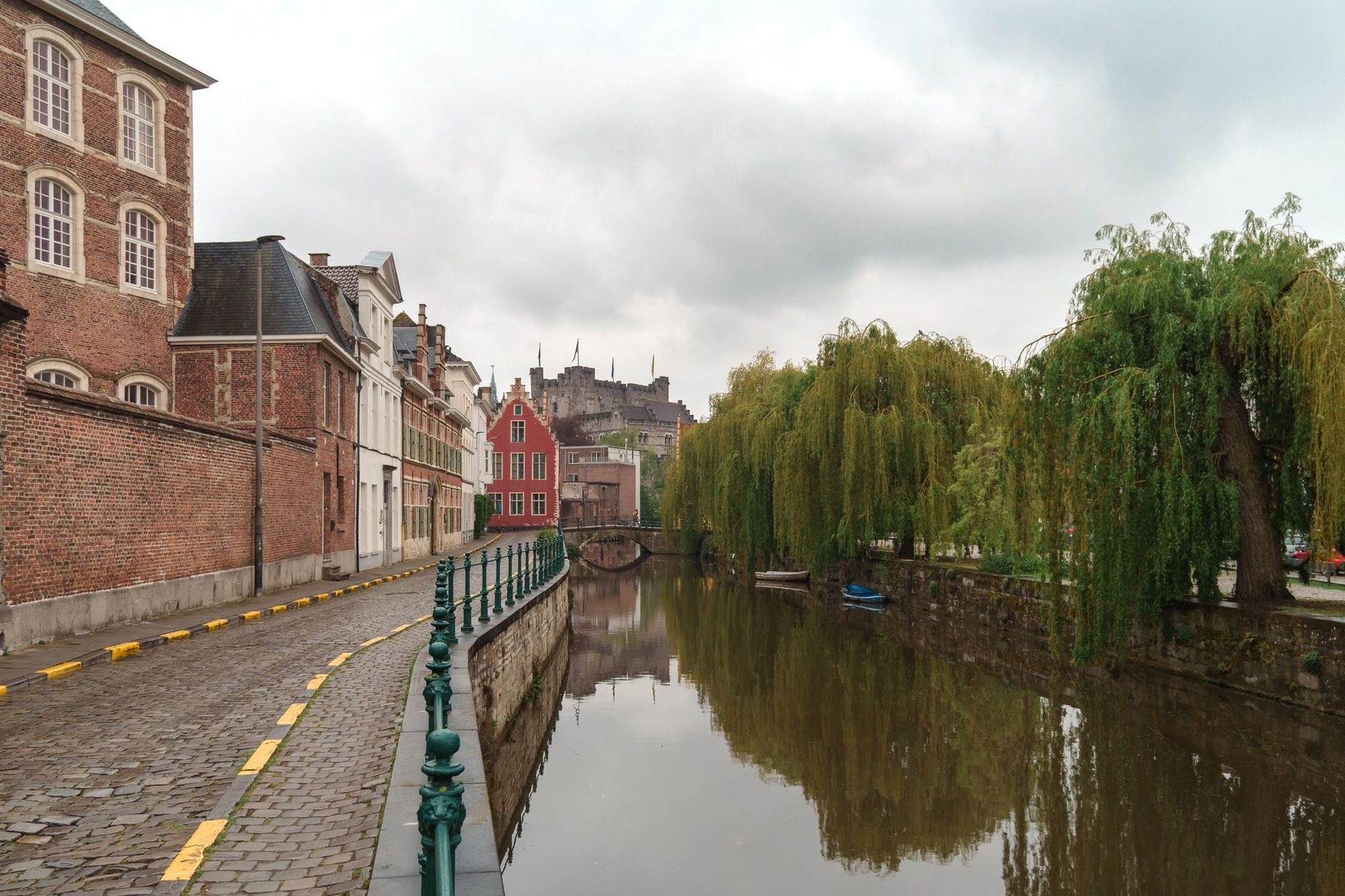 Moated medieval fortress of Gravensteen with stone battlements surrounded by calm canals in Ghent Belgium