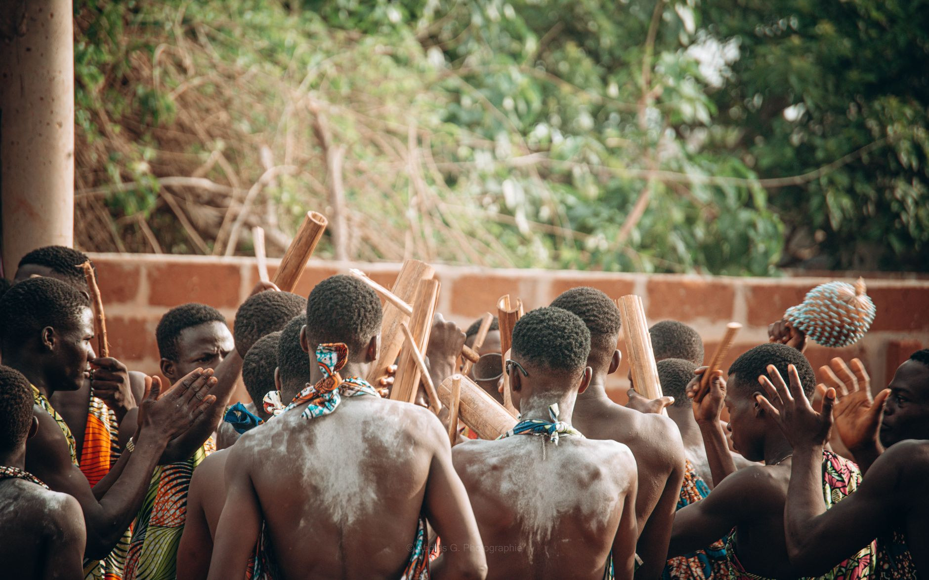 Men gathered in hand-woven garments participating in traditional ceremonial rites in Benin