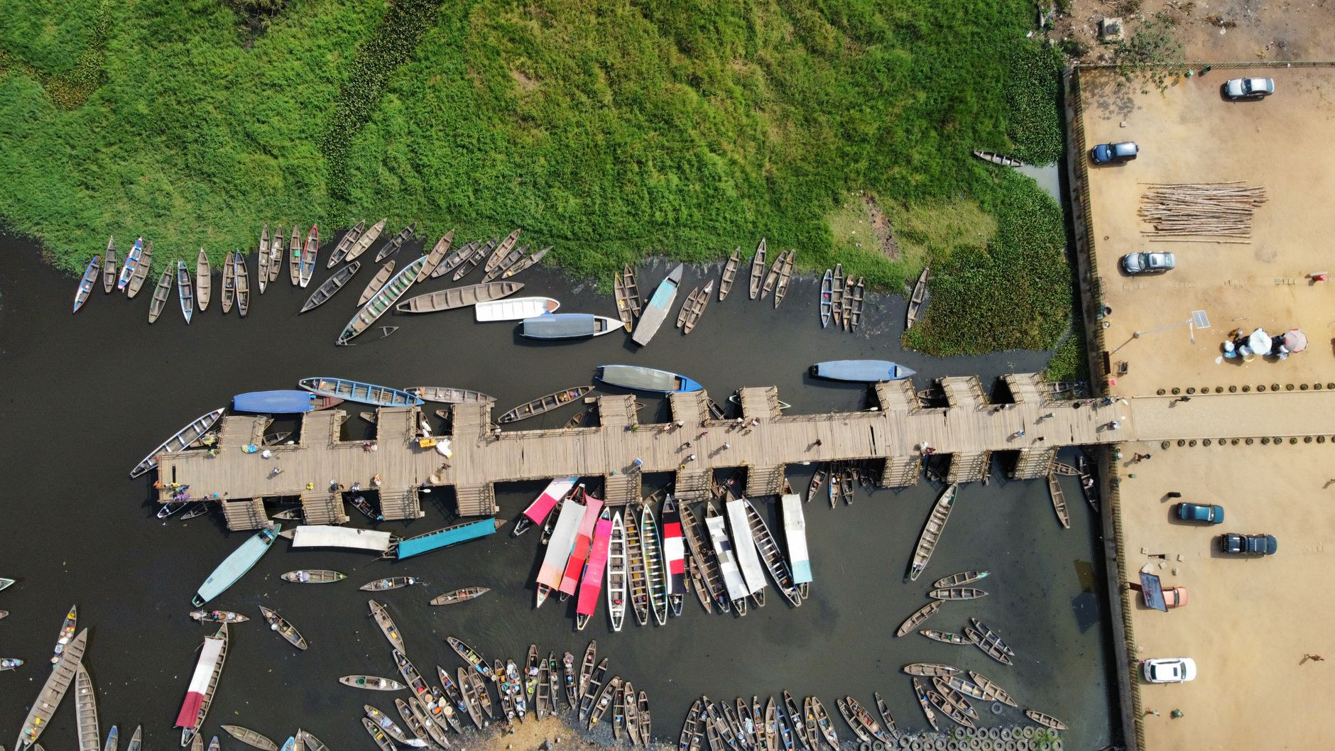 Wooden pirogues and passenger boats moored along the embarcadere boat pier in Abomey-Calavi