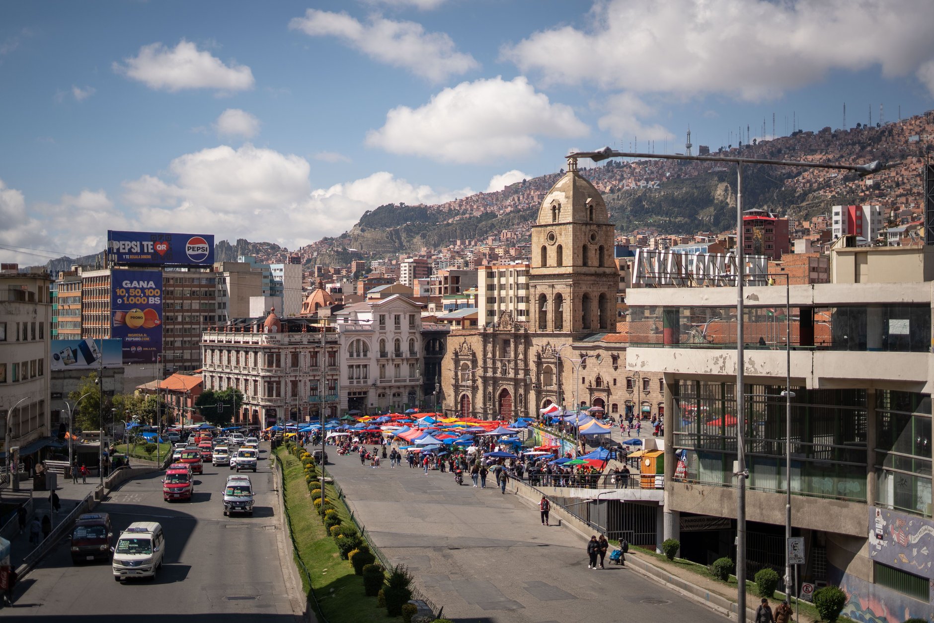 Colorfully woven Andean textiles, herbs, dried llama fetuses, and ritual amulets displayed on street stalls at Mercado de las Brujas in La Paz