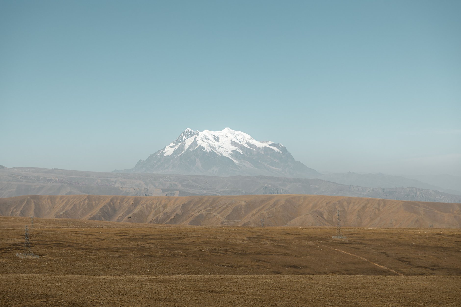 Red conical peak of Cerro Rico towering over the historic colonial churches and tiled roofs of high-altitude Potosi