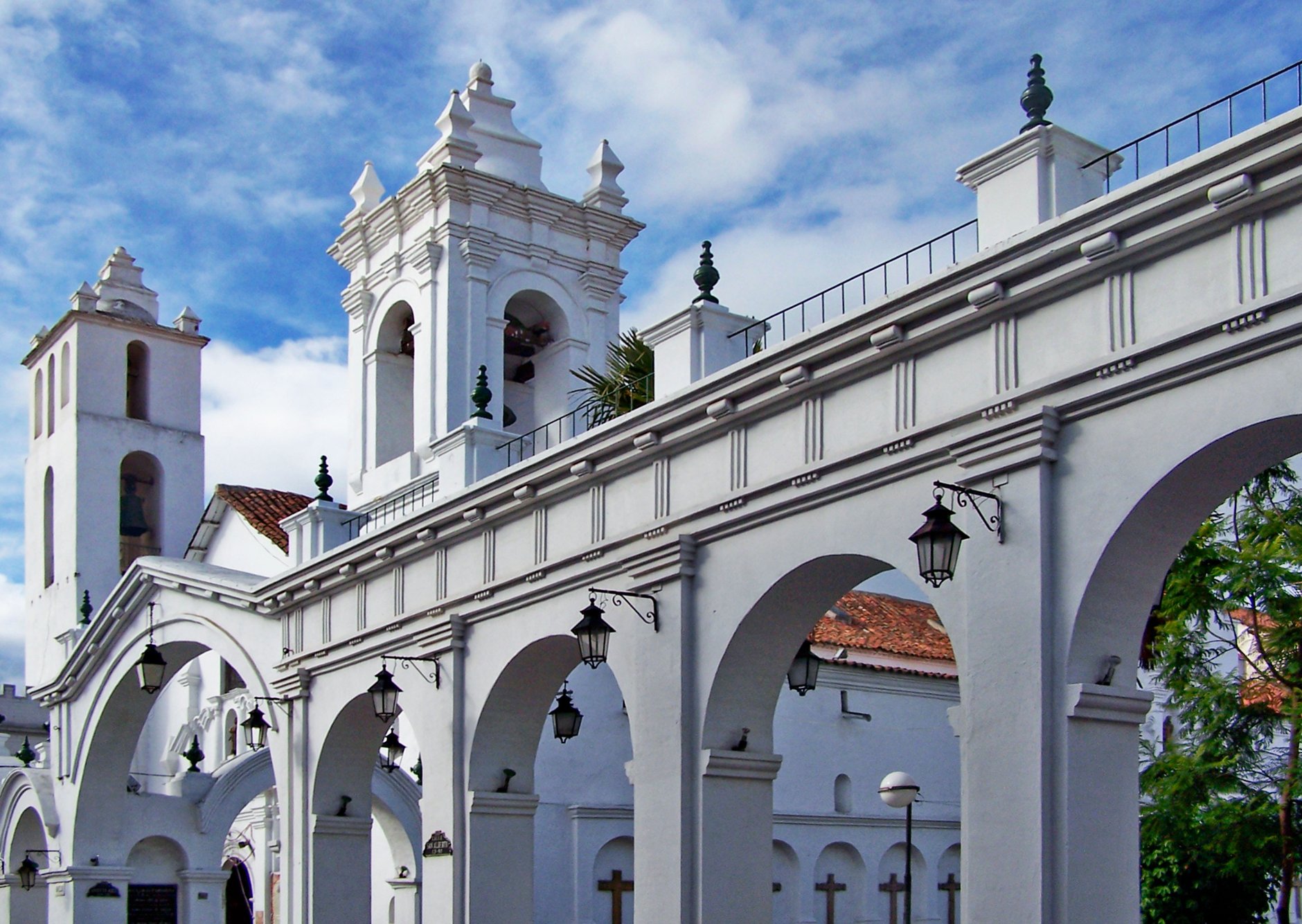 Whitewashed colonial arcades and bell towers of historic Sucre, Bolivia's constitutional capital, under brilliant blue Andean skies