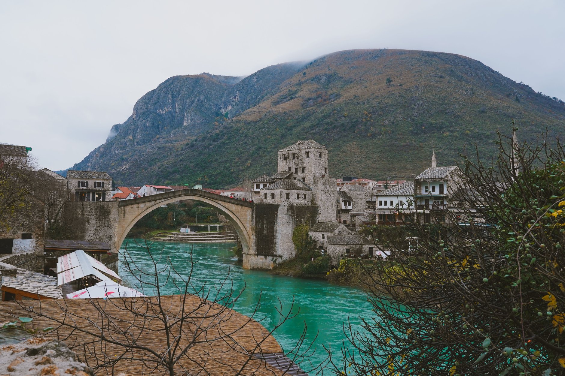 Winding emerald green waters of the Neretva River cutting through towering limestone canyon walls along the mountain train line