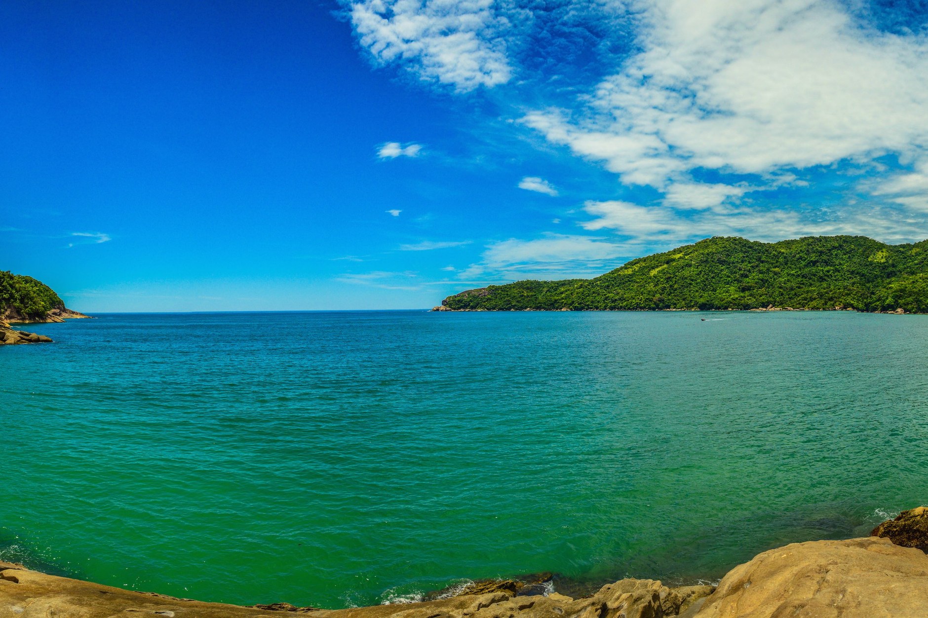 A traditional wooden schooner boat cruising through the island-studded tropical bay of Paraty