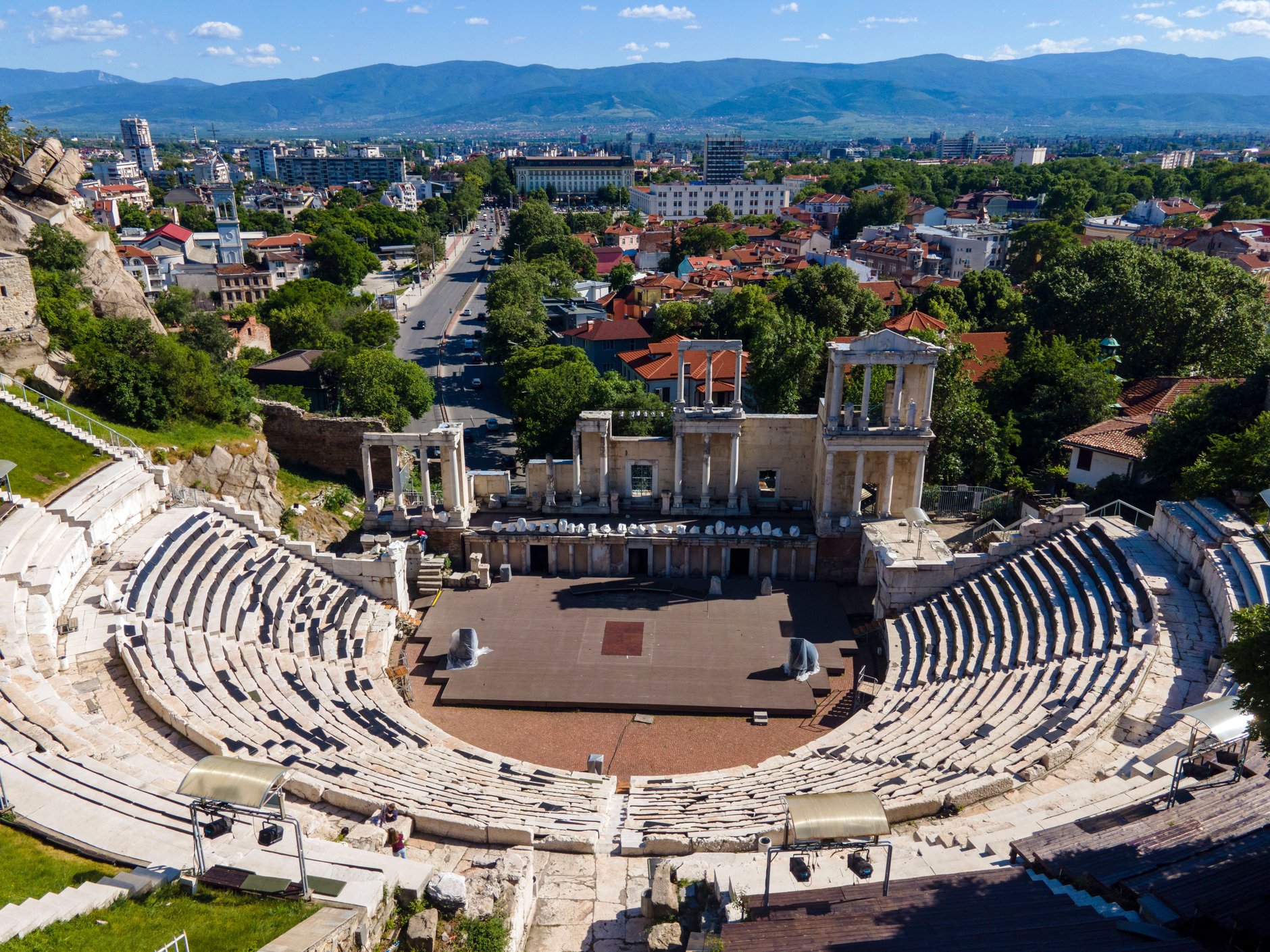 Ancient marble tiered seating and restored colonnade of the Roman theatre of Philippopolis overlooking Plovdiv and the Rhodope Mountains