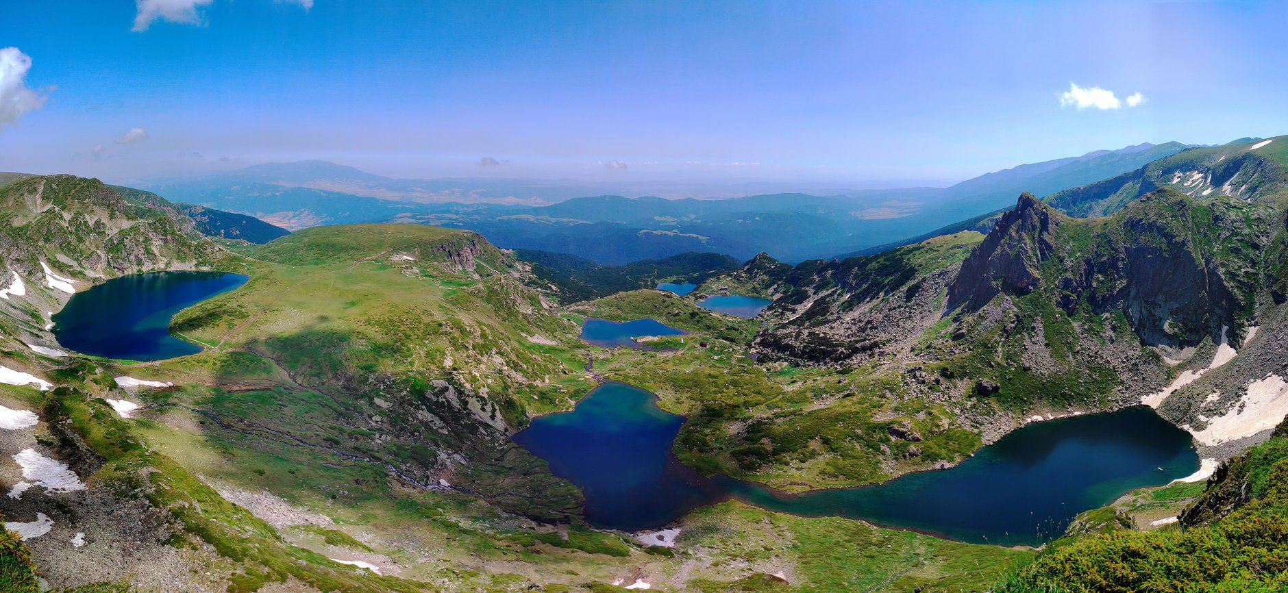Glacial cirque basin of the Seven Rila Lakes surrounded by rugged mountain ridges and alpine wildflowers in summer