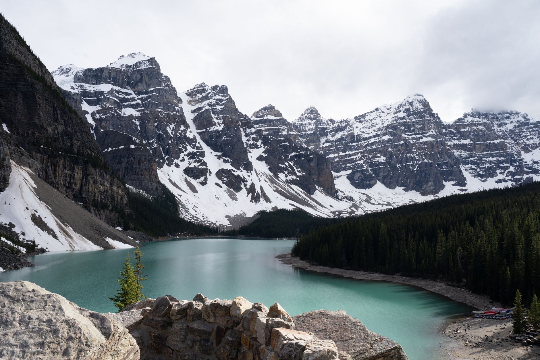 Vibrant blue water of Moraine Lake beneath the sheer Valley of the Ten Peaks