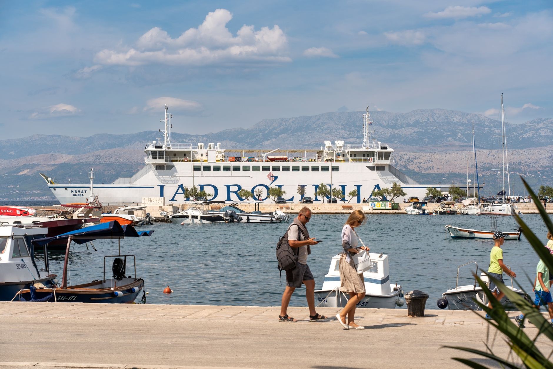 High-speed passenger catamaran ferry slicing through open blue waters between Croatian islands