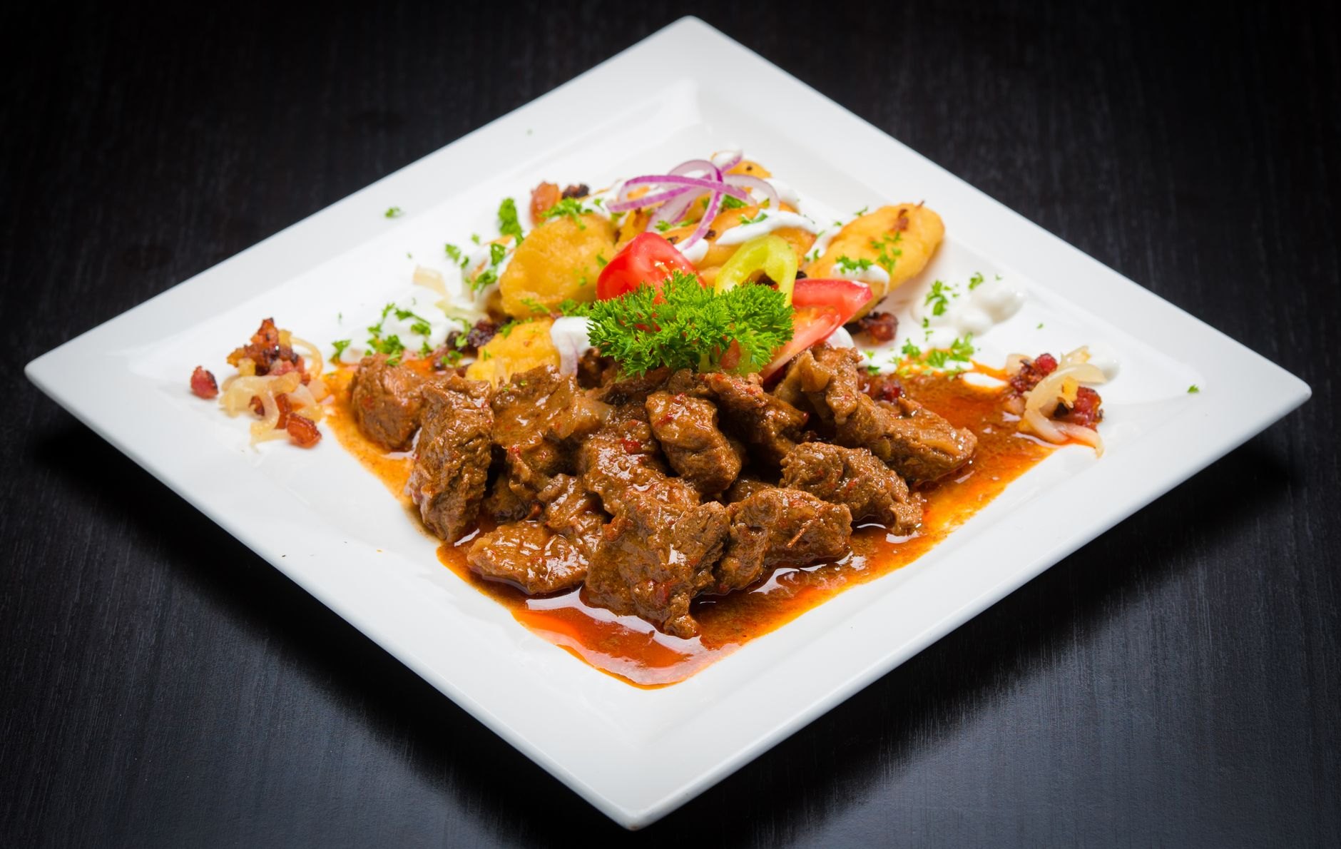 Tender braised beef sirloin served with creamy vegetable sauce, fluffy bread dumplings, cranberries, and lemon